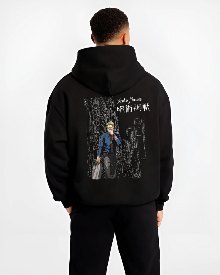 Black hoodie worn by a male model, back view, featuring Jujutsu Kaisen Nanami Kento retro streetwear graphic with neon cityscape manga artwork design.