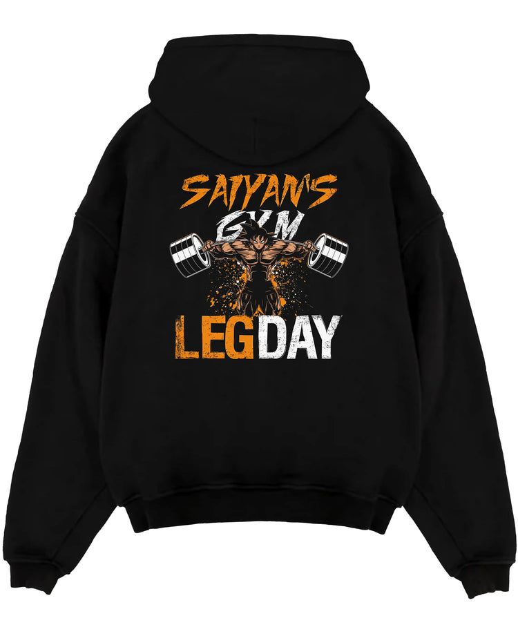 Black pullover hoodie laid flat on a white background, featuring Saiyan’s Gym Leg Day retro manga graphic with muscular anime-inspired character lifting weights.