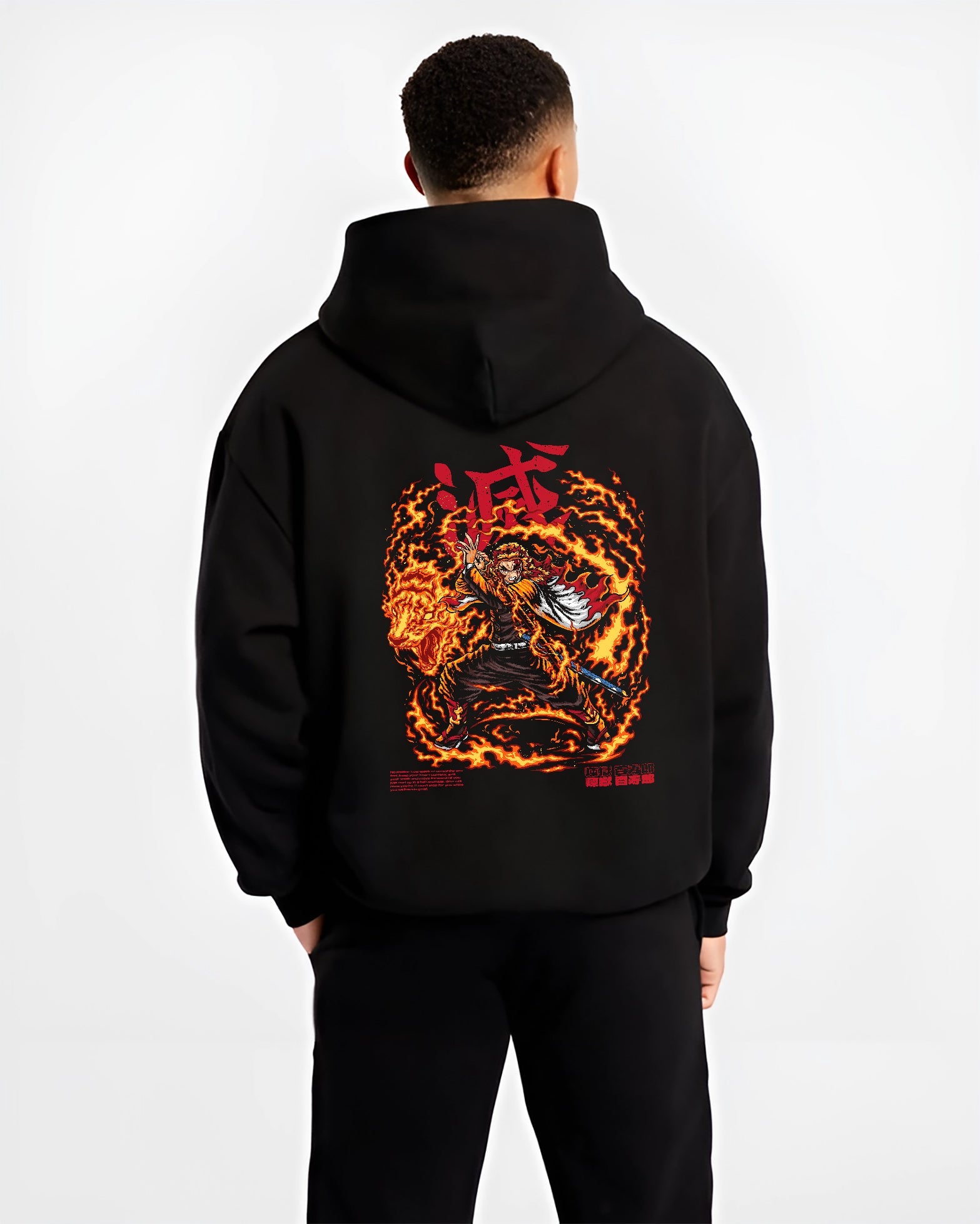 Black hoodie worn by a male model, back view, featuring Demon Slayer Rengoku shonen battle character artwork in anime poster inspired style with blazing fire aura.