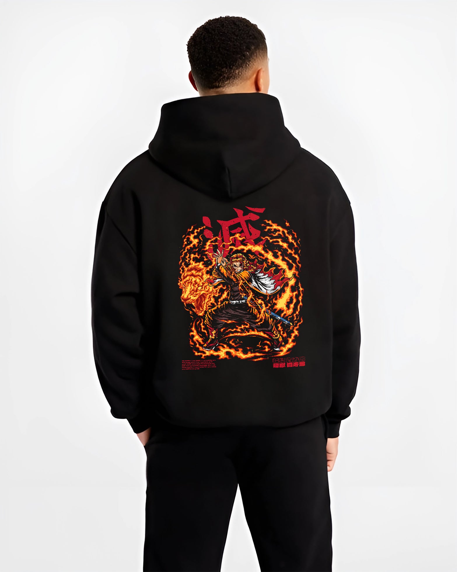 Black hoodie worn by a male model, back view, featuring Demon Slayer Rengoku shonen battle character artwork in anime poster inspired style with blazing fire aura.