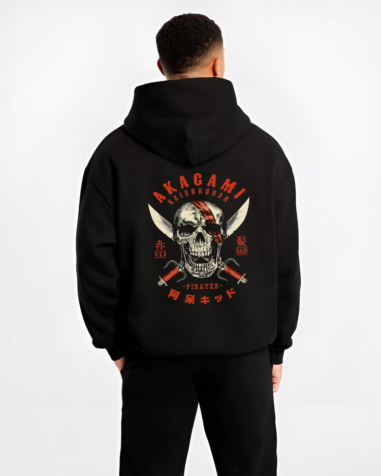 Black hoodie worn by a male model, back view, featuring Akagami Red Hair Pirates skull cult comic style artwork with retro streetwear tones.