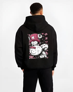 Black hoodie worn by a male model, back view, featuring One Piece Tony Tony Chopper anime poster inspired artwork in bright pink retro streetwear style.