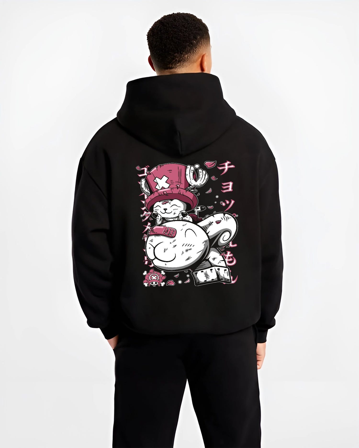 Black hoodie worn by a male model, back view, featuring One Piece Tony Tony Chopper anime poster inspired artwork in bright pink retro streetwear style.