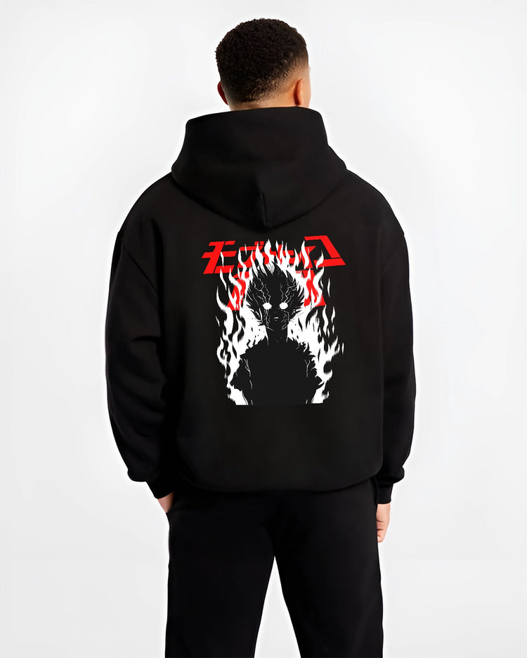 Black hoodie worn by a male model, back view, featuring Mob Psycho 100 fiery silhouette anime poster style artwork with dark manga aesthetic.