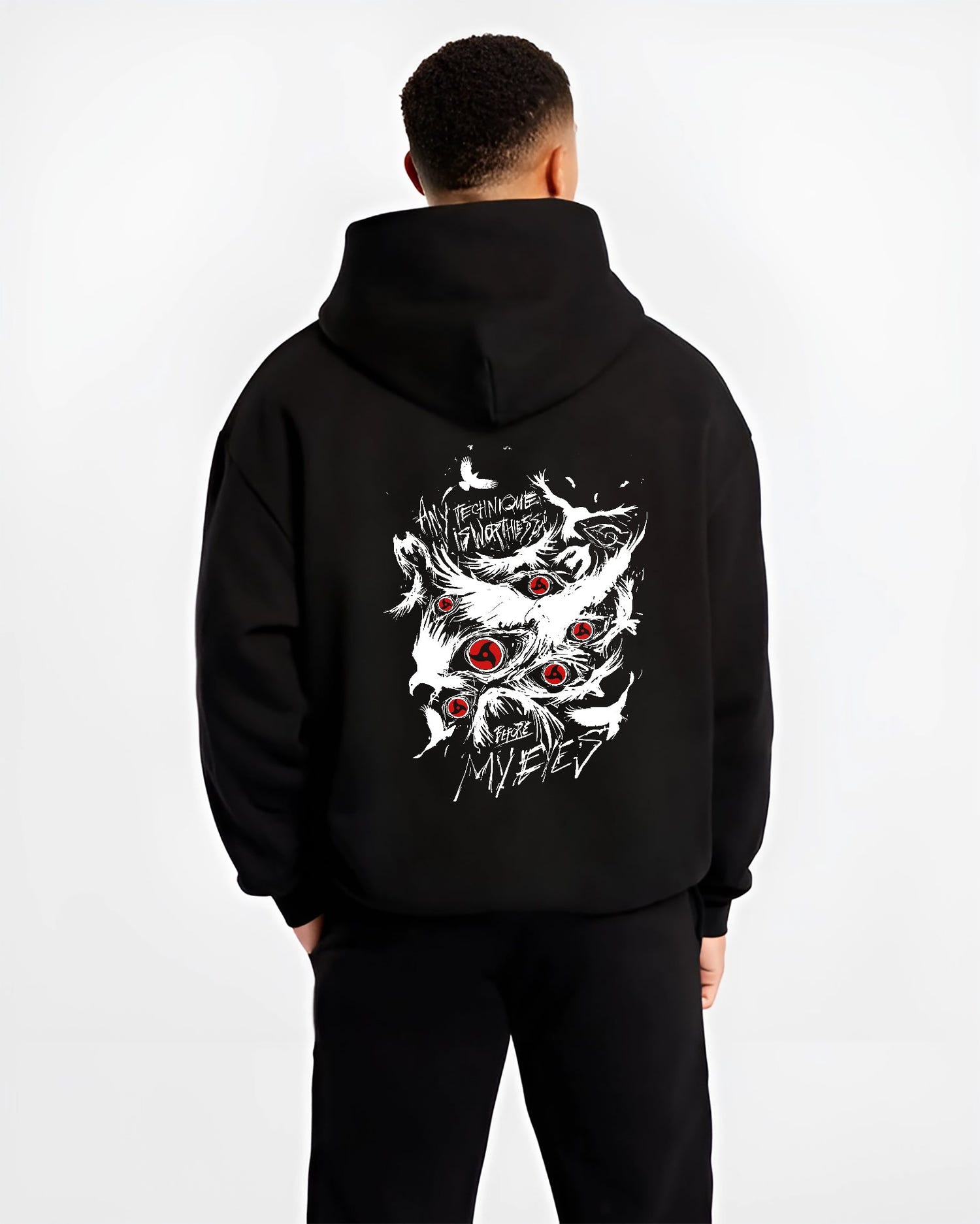 Black hoodie worn by a male model, back view, featuring Naruto Sharingan Japanese animation streetwear design with striking red eye graphics and distressed text.