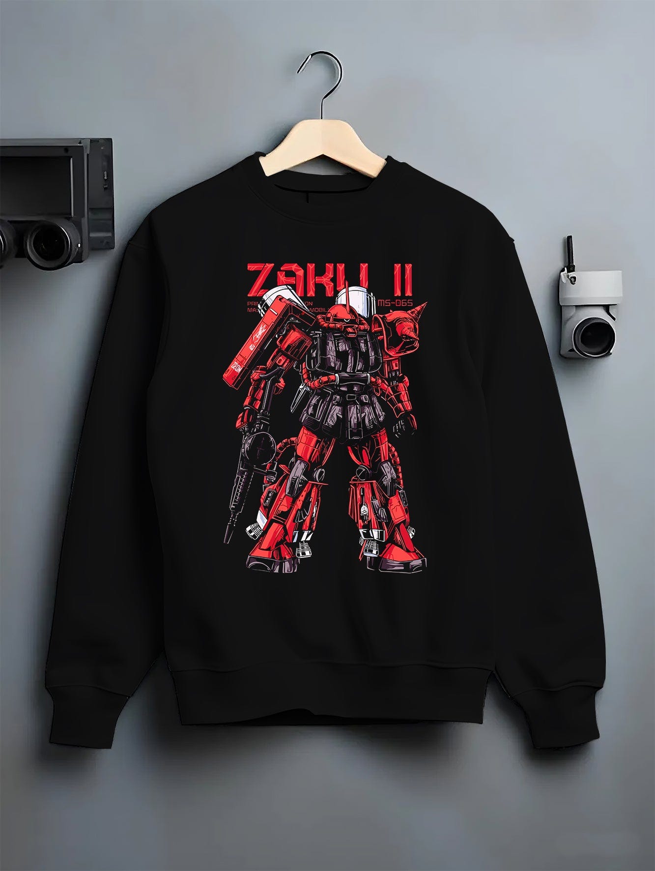 Black crewneck sweatshirt on a hanger against a grey wall, featuring Zaku II retro mecha Gundam inspired design in anime poster style artwork.