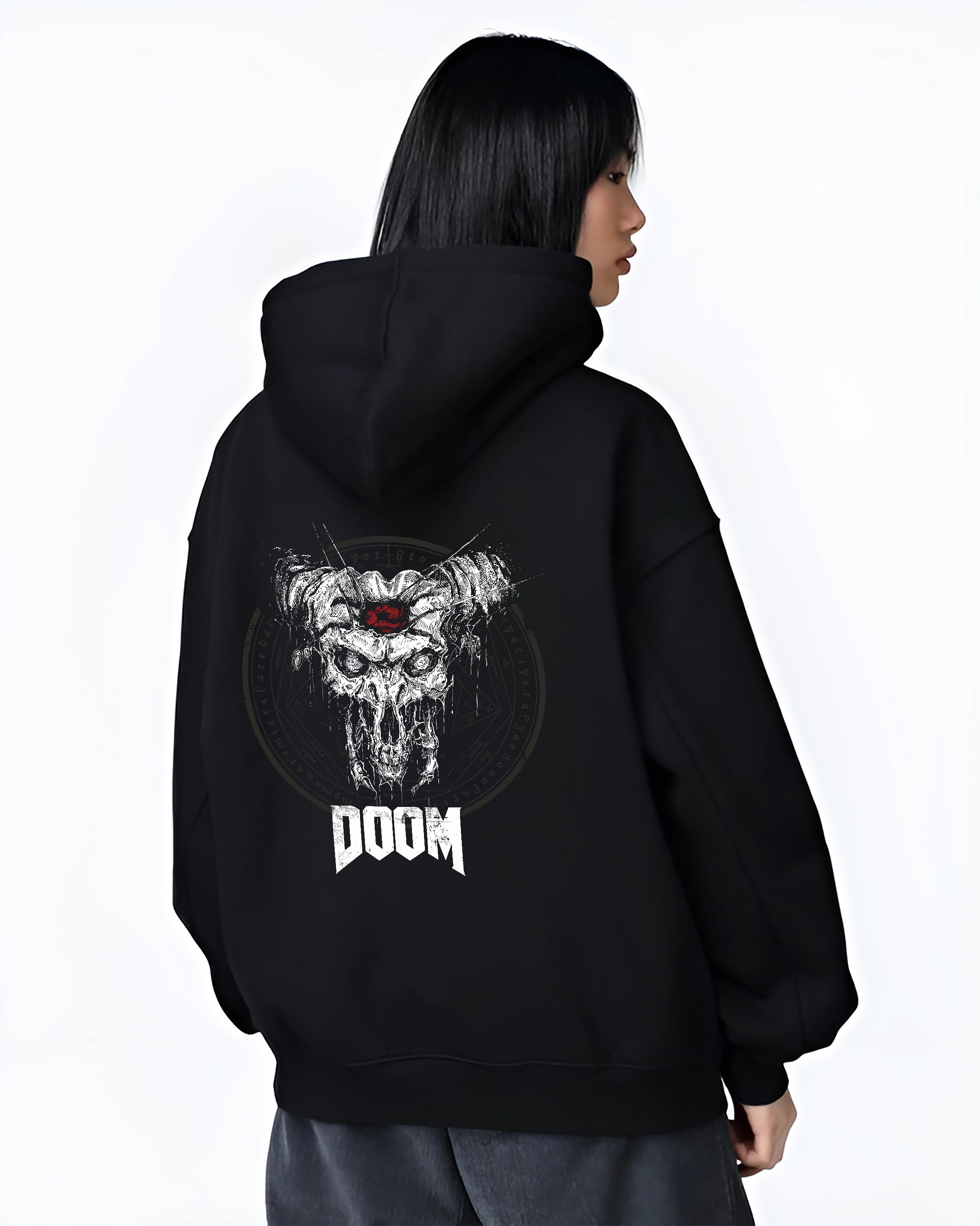 Black hoodie worn by a female model, back view, featuring DOOM skull with horns design in dark horror aesthetic and vintage retro distressed style.