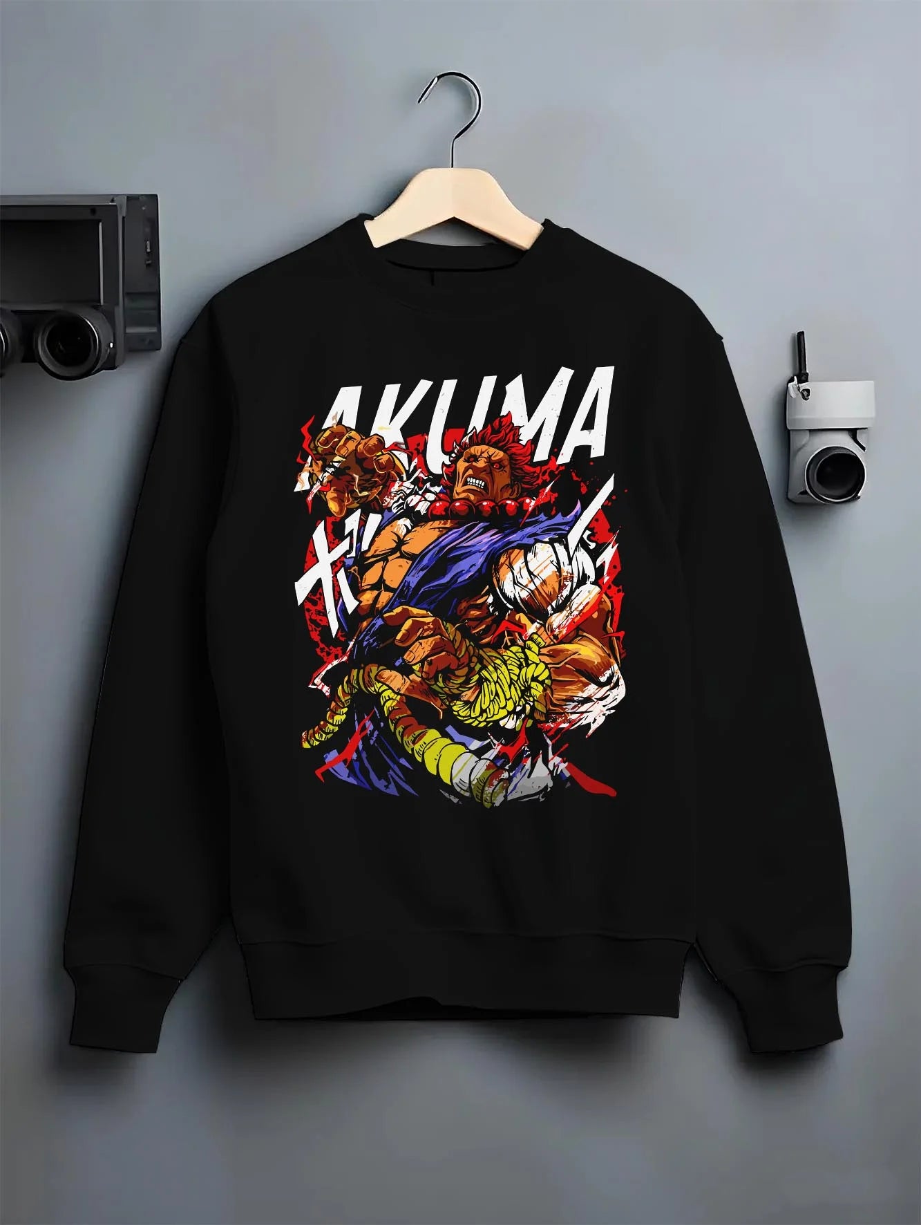 Black crewneck sweatshirt on hanger with Akuma Max Power Hoodie Street Fighter Fiery Demon Aura graphic Akuma anime design.