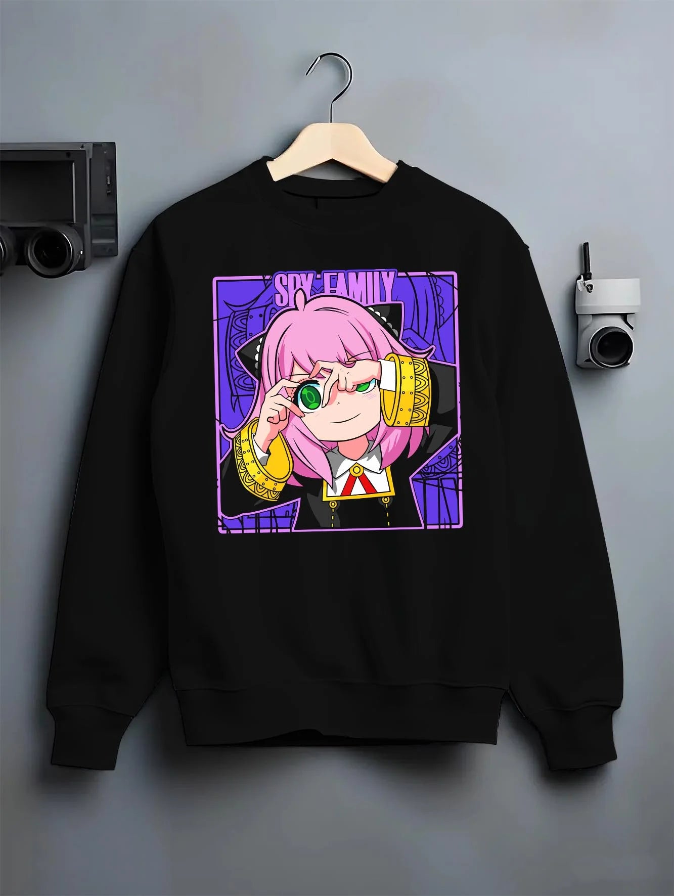 Black crewneck sweatshirt on hanger with Anya Forger Hoodie Spy x Family Magnifying Glass Scene graphic streetwear graphic.