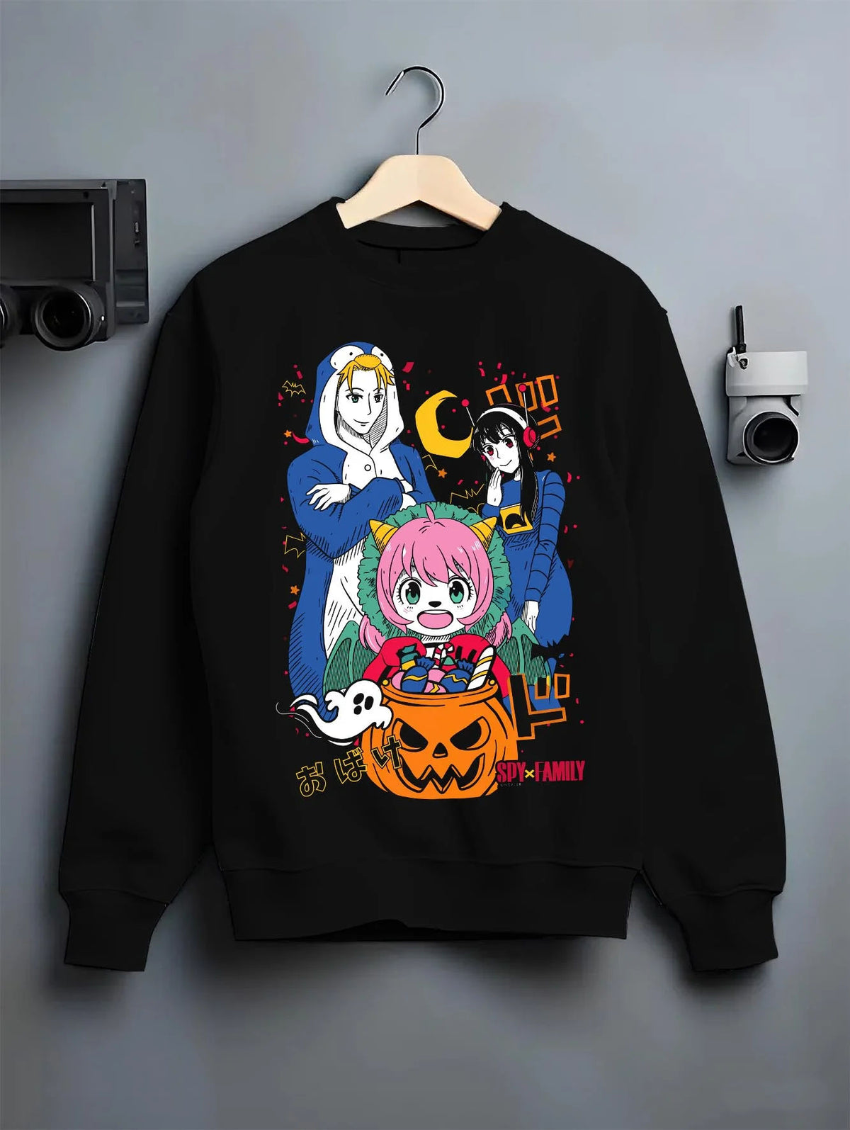 Black crewneck sweatshirt on hanger featuring Anya Forger Halloween Spy x Family pumpkin-night artwork.