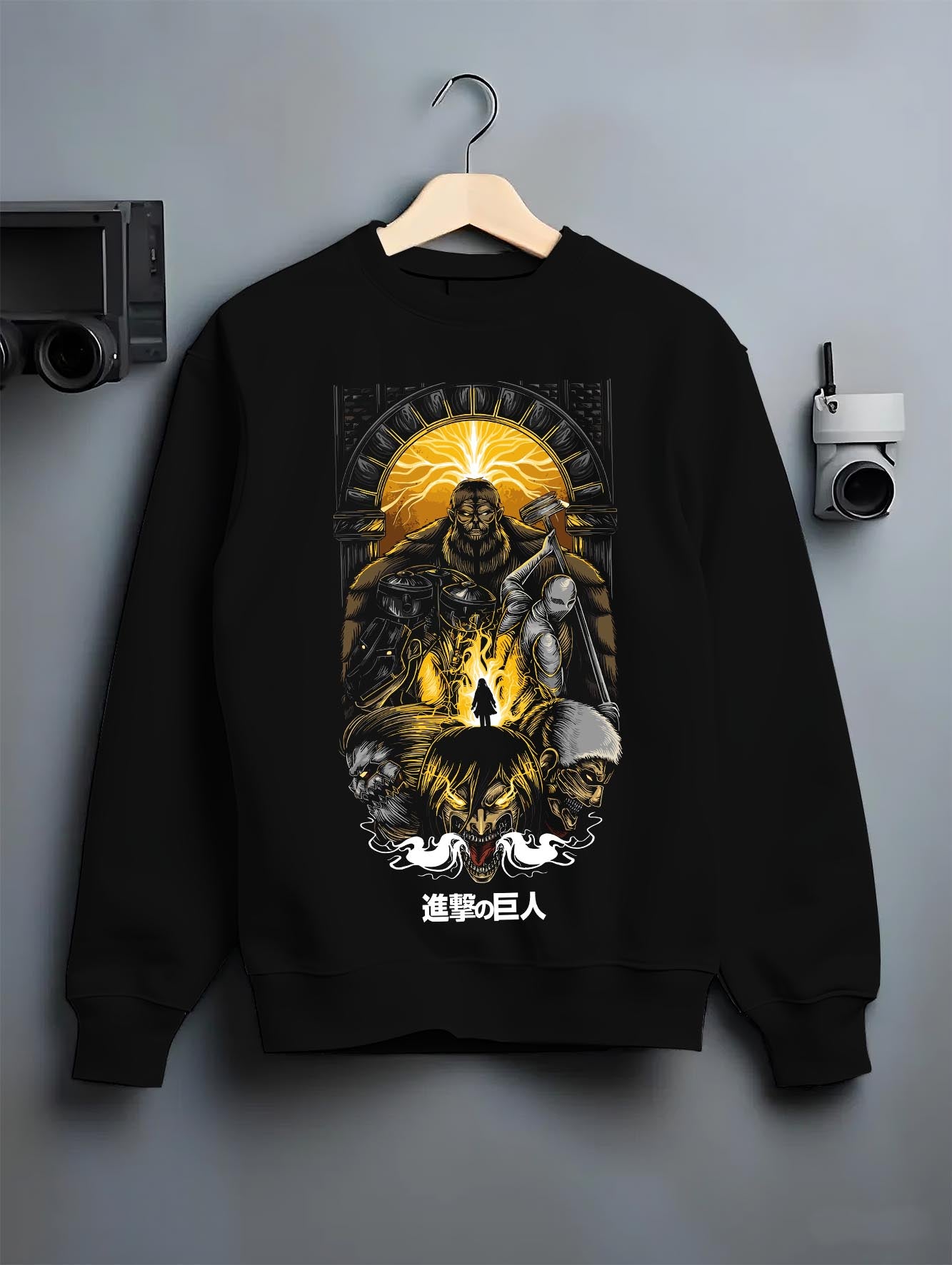Black crewneck sweatshirt on a hanger against a grey wall, featuring Attack on Titan anime poster inspired design with retro manga artwork print and dystopian anime aesthetic.