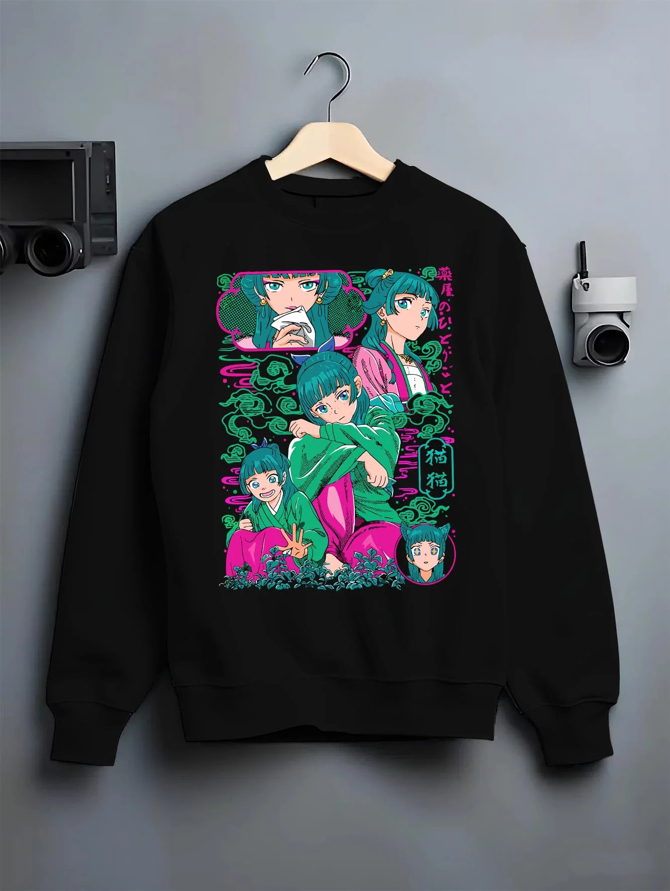 Black crewneck sweatshirt on hanger with Apothecary Diaries Hoodie Maomao Pink Hair Trio Panel graphic bold anime graphic.