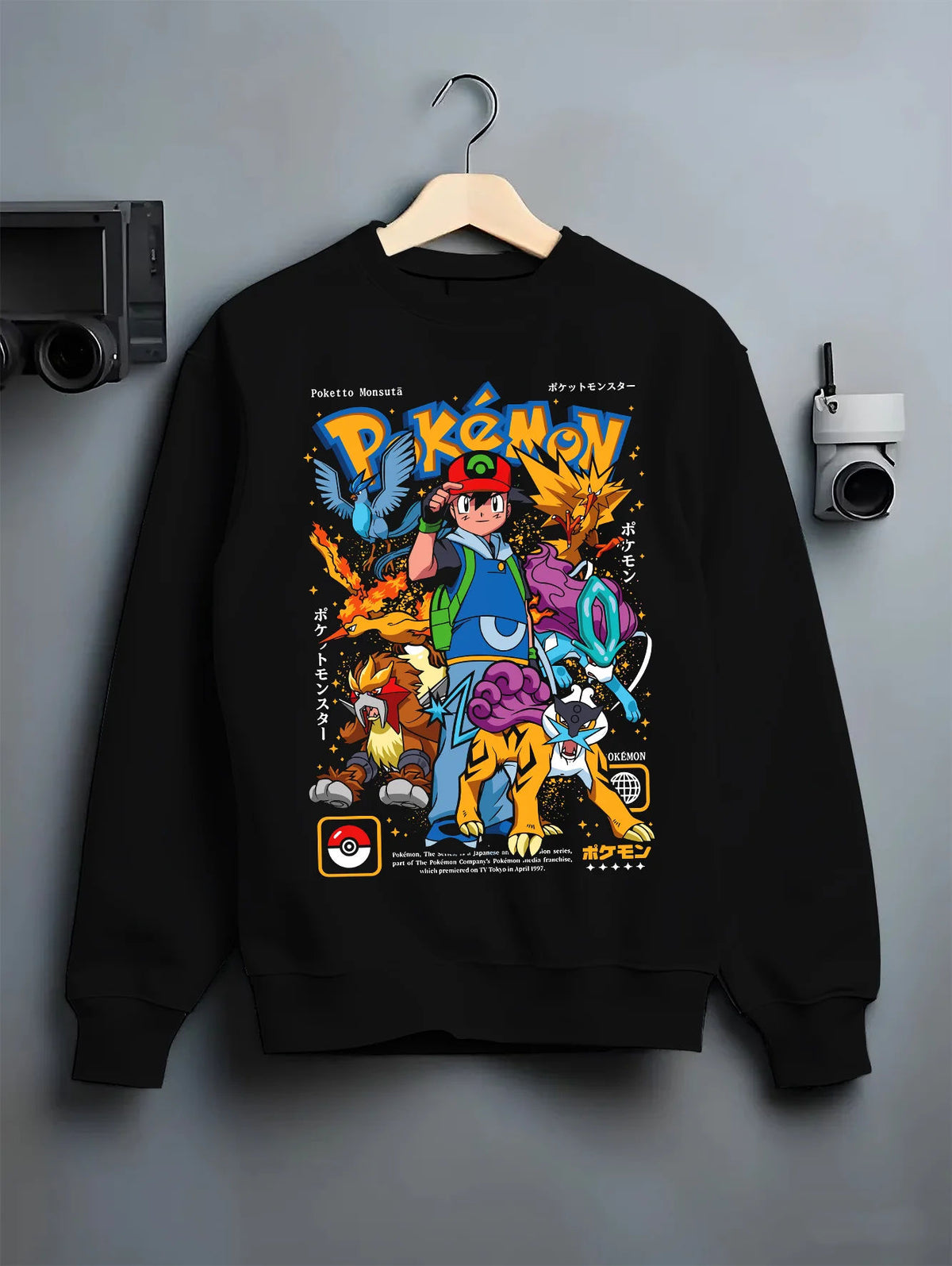 Black crewneck sweatshirt on hanger with Ash Ketchum and Pokémon illustrated back graphic