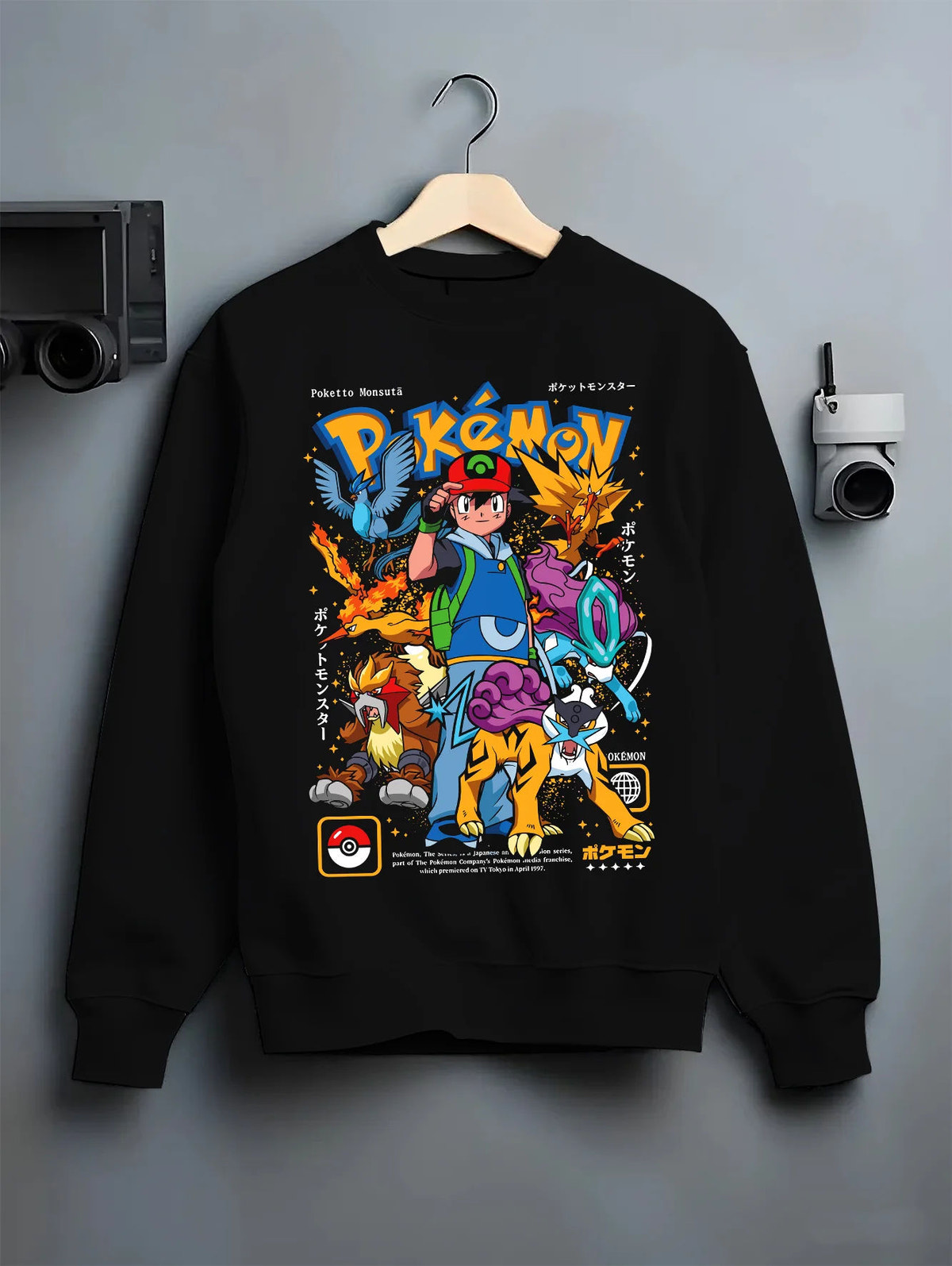 Black crewneck sweatshirt on hanger with Ash Ketchum and Pokémon illustrated back graphic