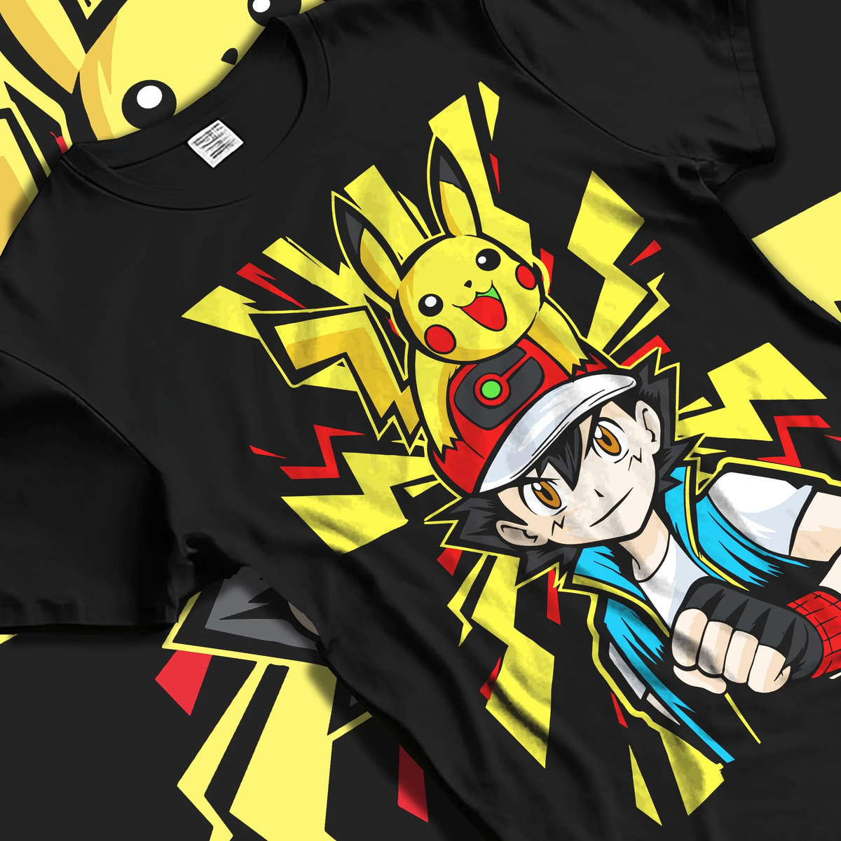 Black T-shirt laid flat with natural folds featuring Ash Ketchum and Pikachu Pokémon journey artwork.
