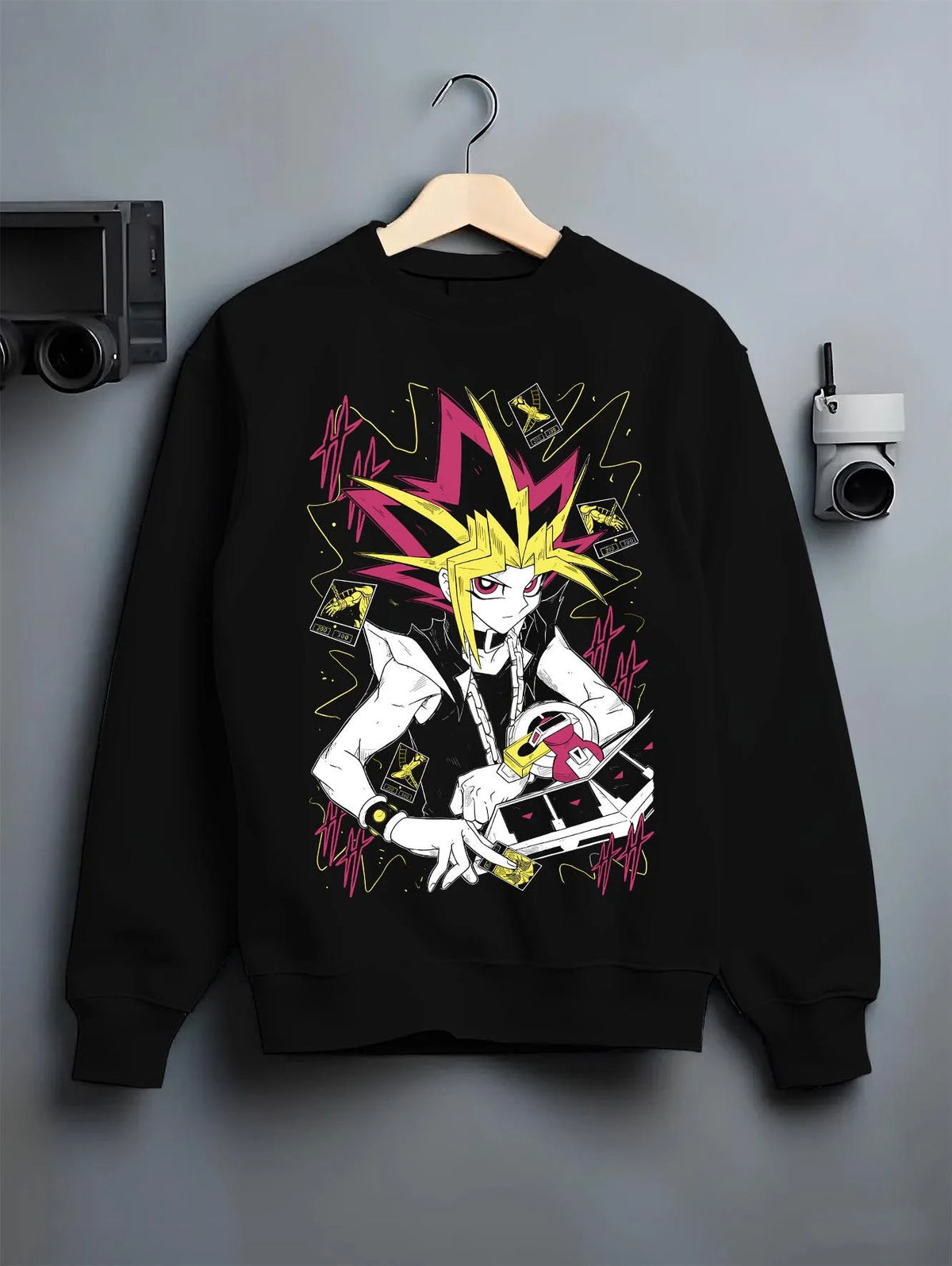 Black crewneck sweatshirt on hanger featuring Atem and Dark Magician Yu-Gi-Oh duel spirit artwork.