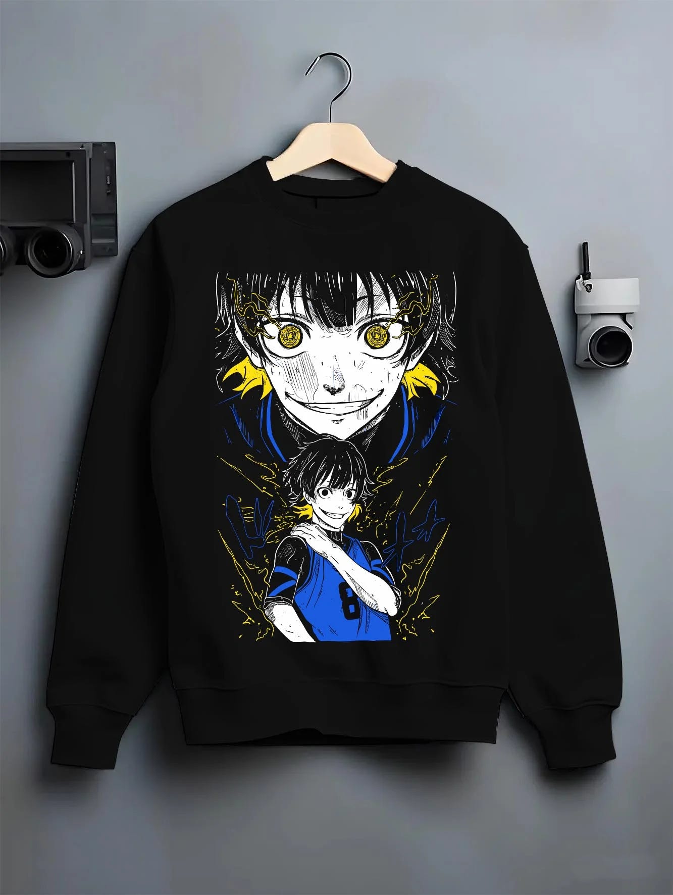 Black crewneck sweatshirt on hanger with Bachi Hoodie Blue Lock Intense Yellow Eyes Stare Down graphic bold anime graphic.