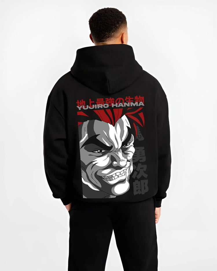 Black hoodie worn by male model, back view with Yujiro Hanma Hoodie Baki the Grappler Fierce Grin graphic premium wear.
