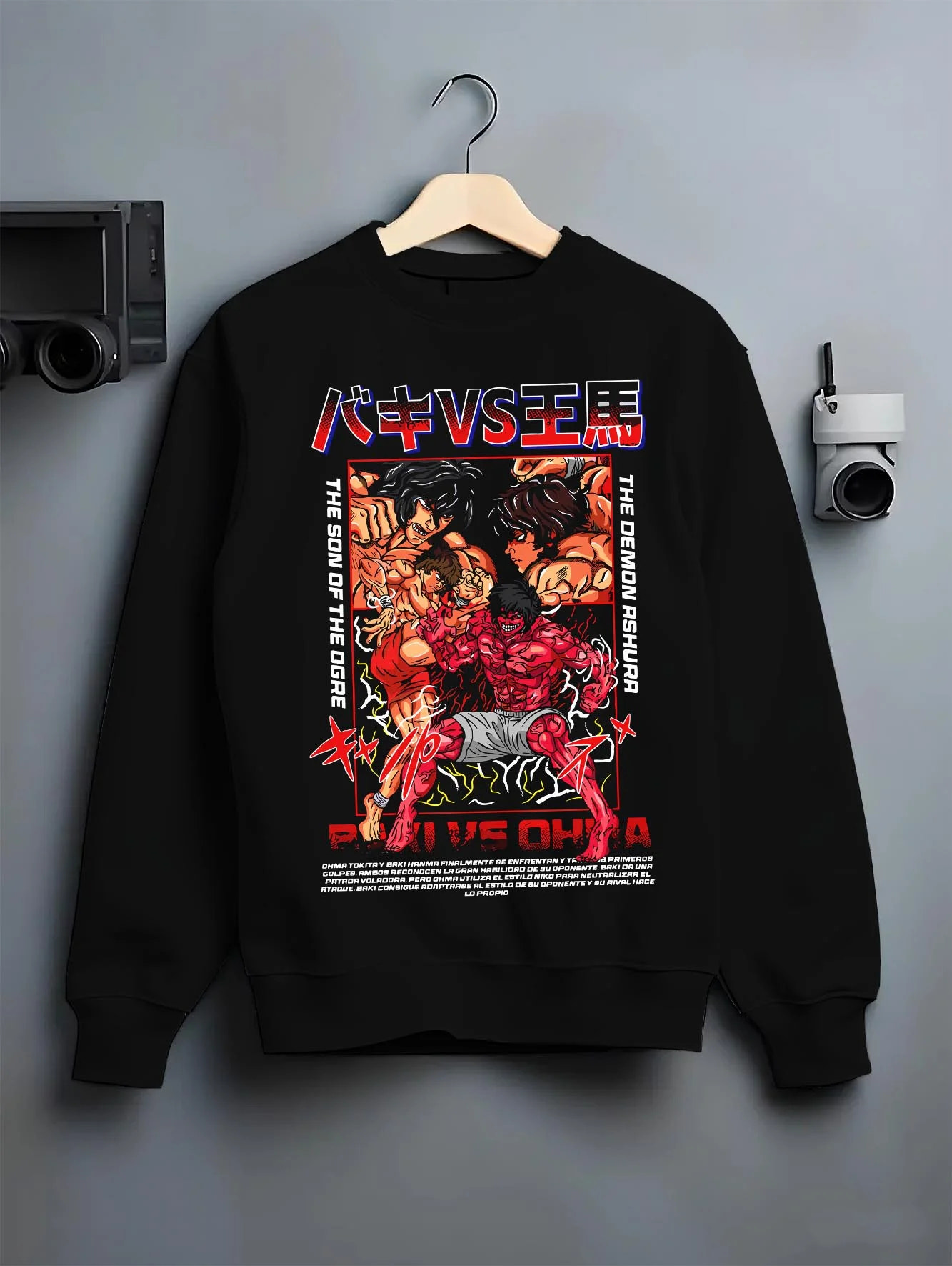 Black crewneck sweatshirt on hanger with Baki vs Ohma Hoodie Baki Hanma Kengan Ashura Showdown graphic premium wear.