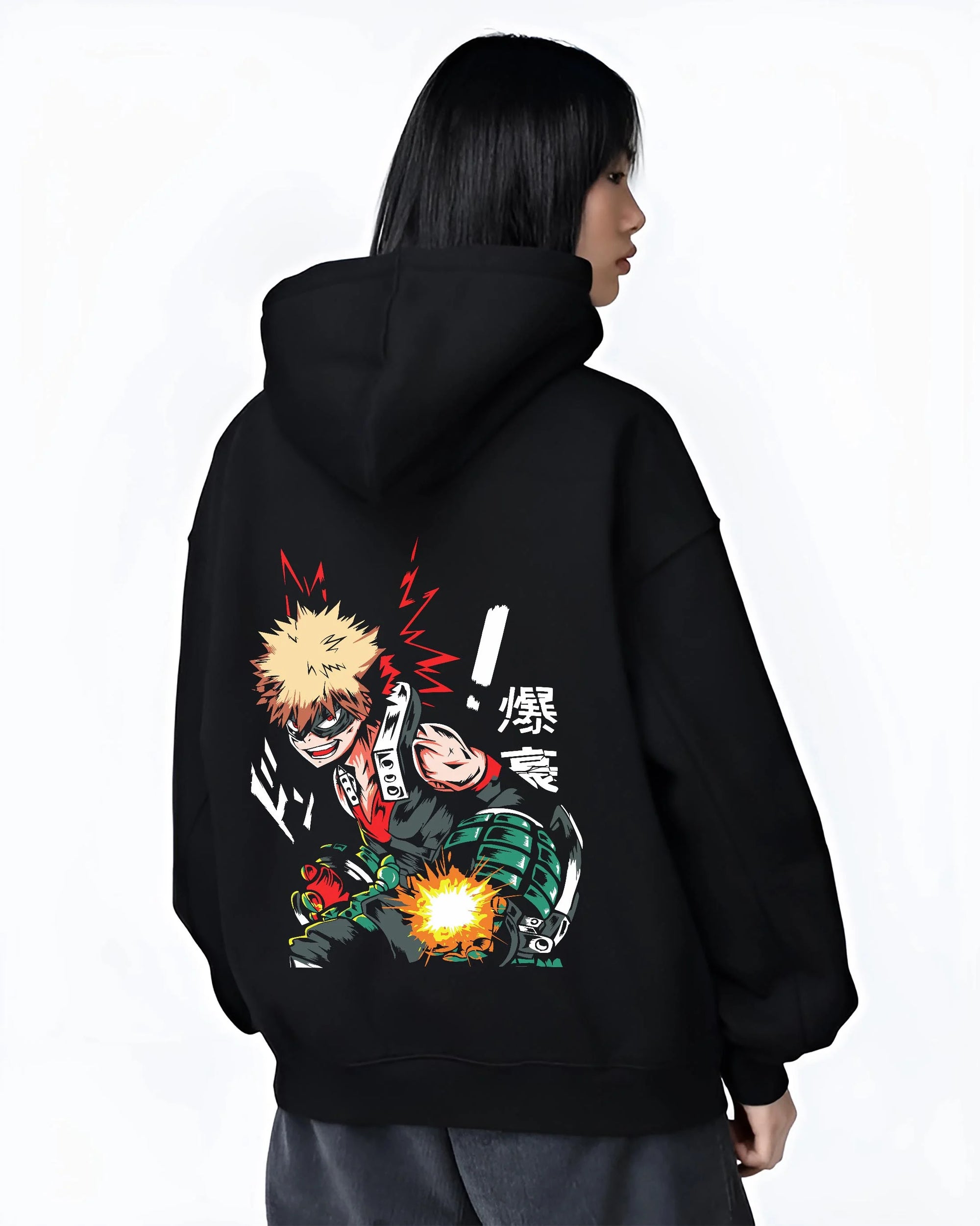 Black hoodie worn by female model, back view with Bakugo Hero Hoodie My Hero Academia Green Blast Scene graphic bold anime graphic.