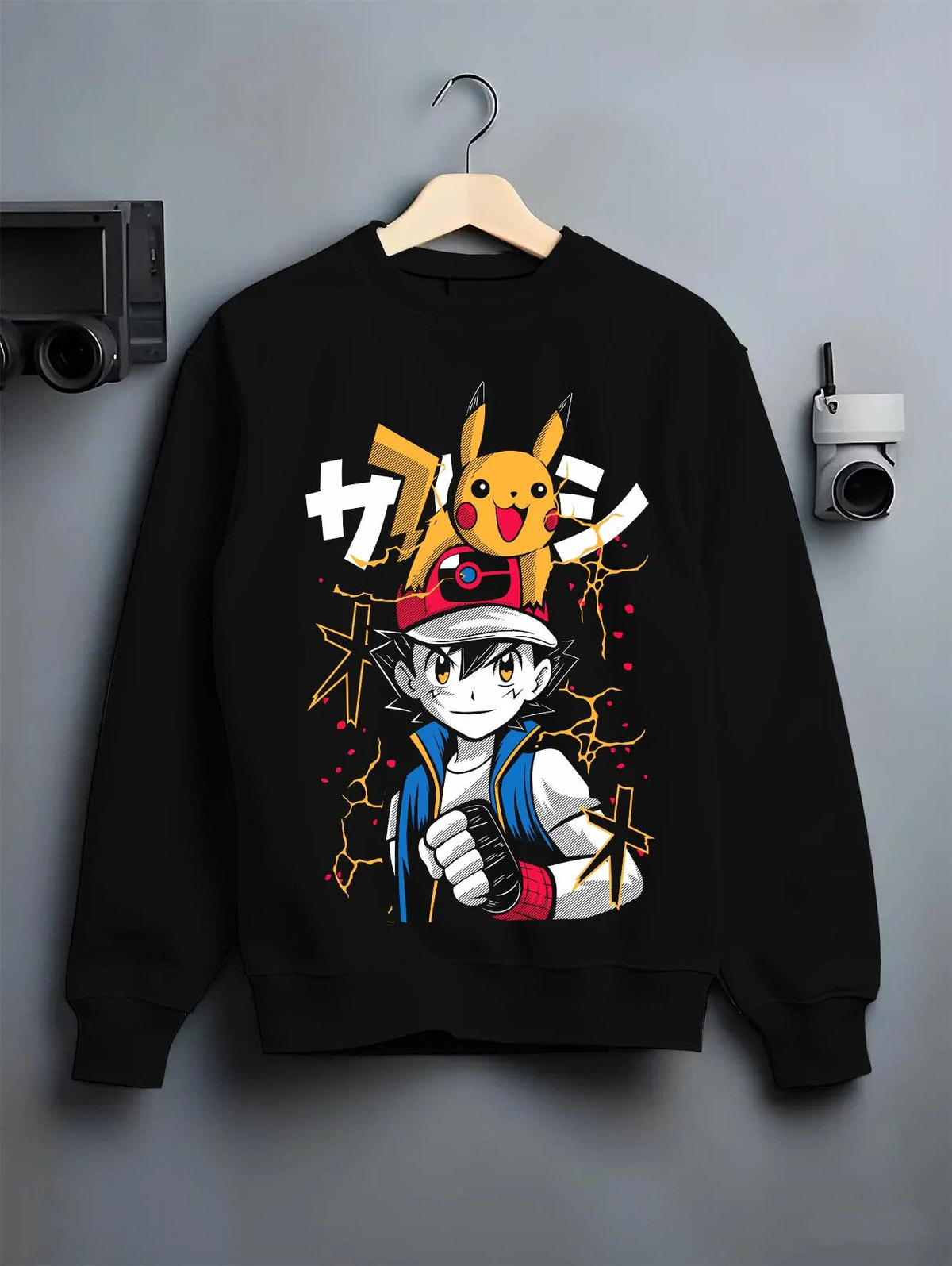 Black crewneck sweatshirt on hanger featuring Ash Ketchum Pikachu Pokémon battle artwork.