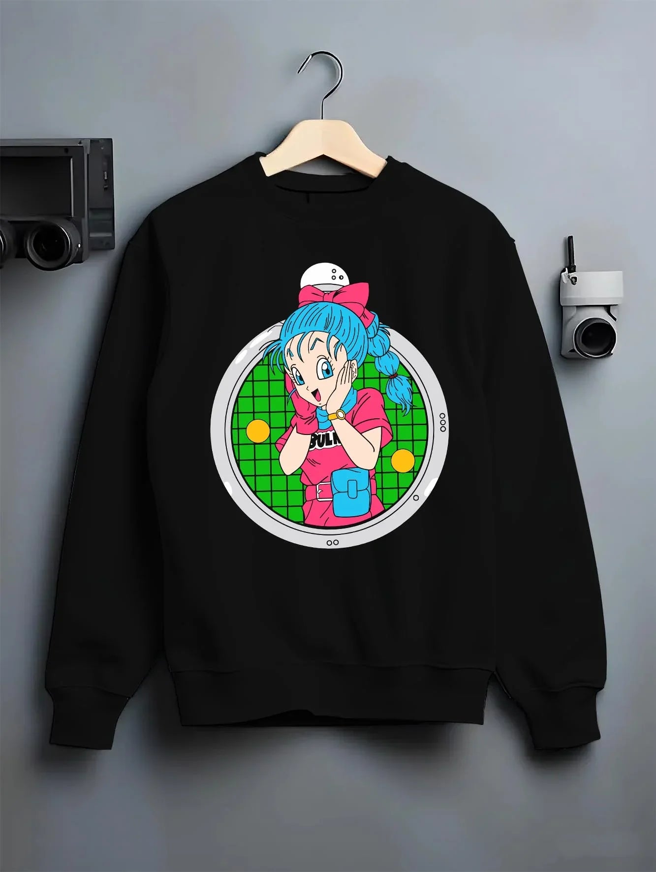 Black crewneck sweatshirt on hanger with Bulma Capsule Corp Hoodie Dragon Ball Z Retro Anime graphic streetwear graphic.