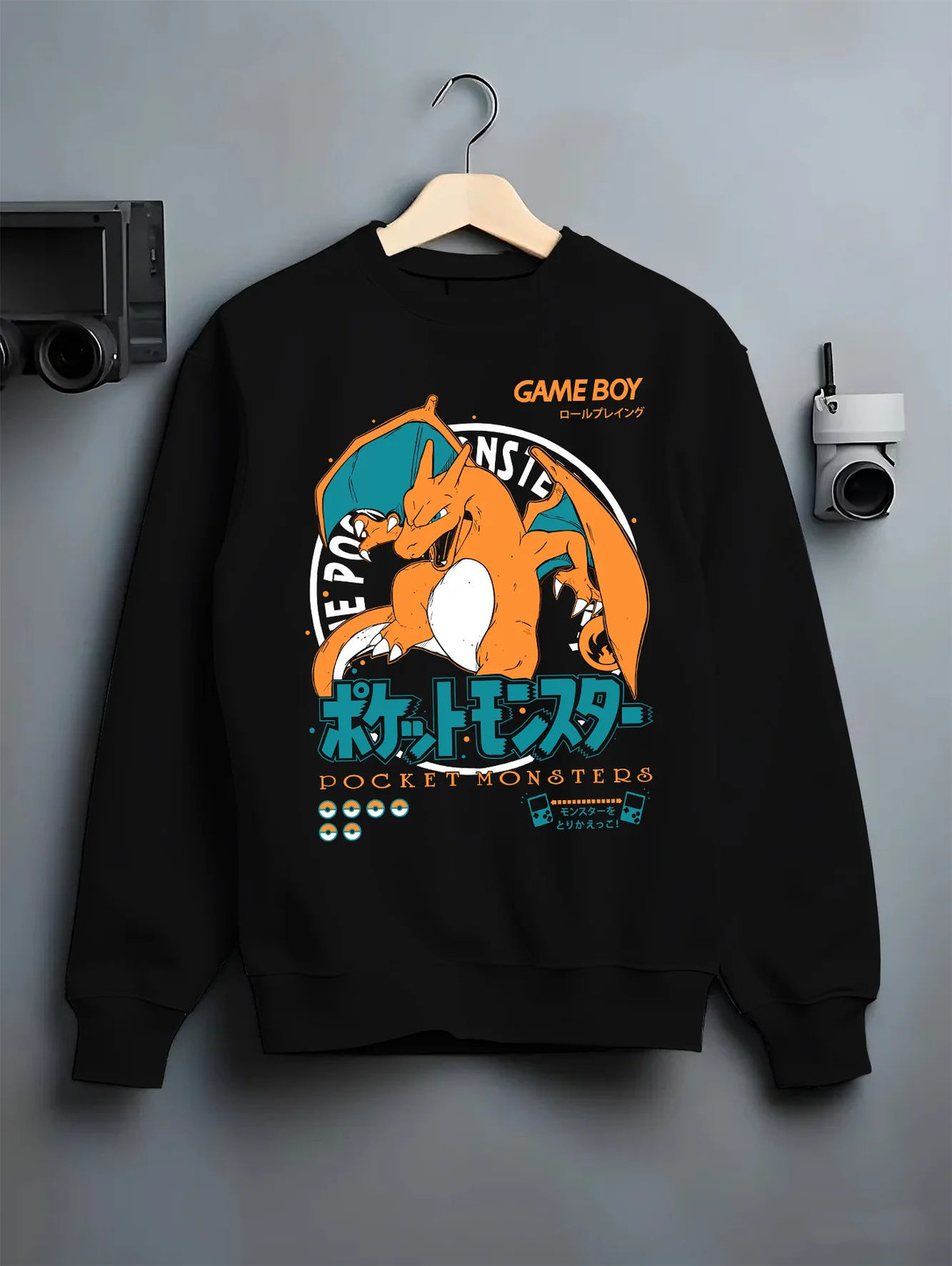 Black crewneck sweatshirt on hanger showing Charizard from Pokémon: Pocket Monsters and Game Boy illustration