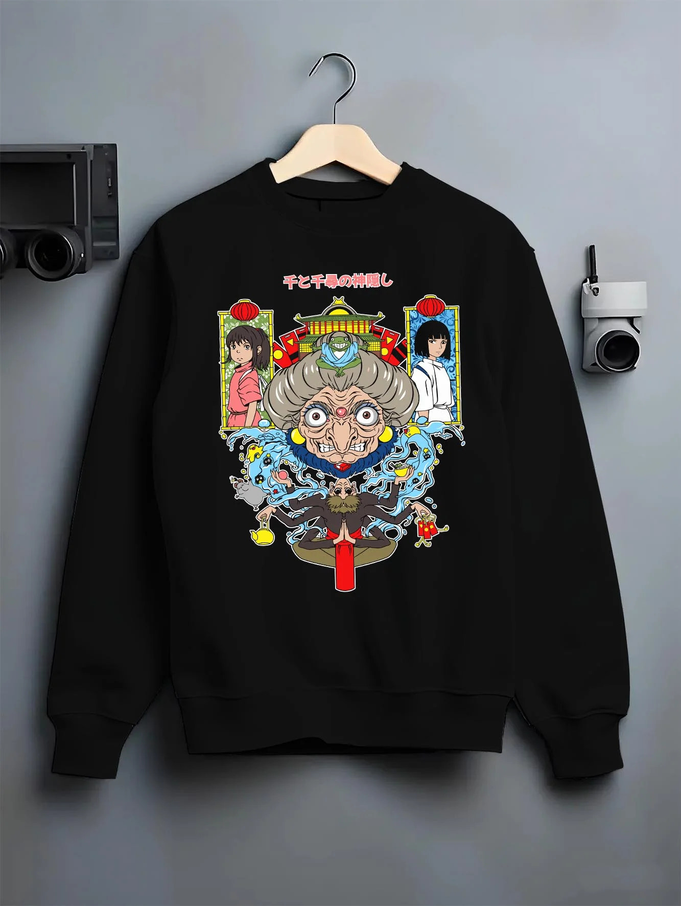 Black crewneck sweatshirt on hanger with Spirited Away Hoodie Yubaba Studio Ghibli Retro Scene graphic streetwear graphic.