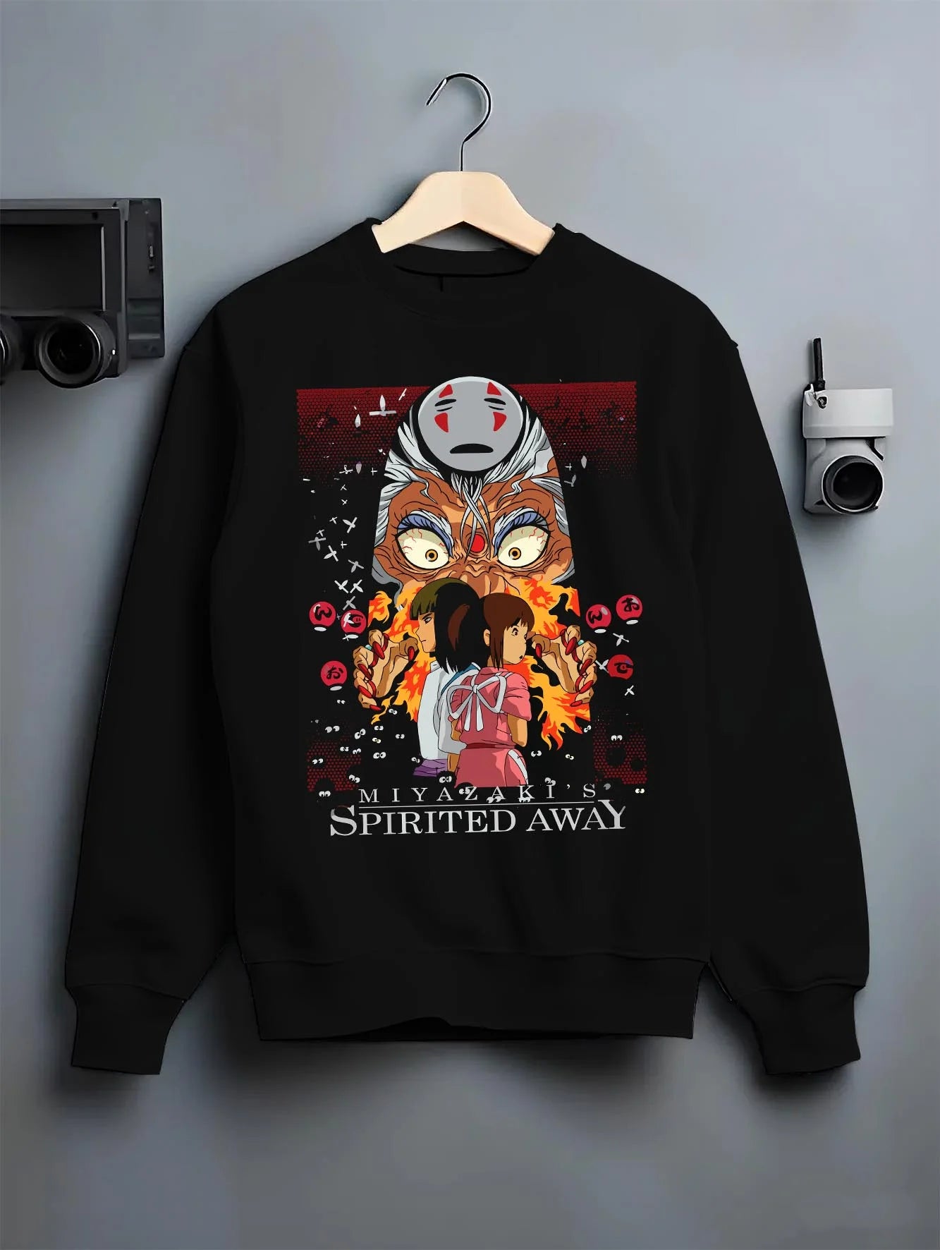 Black crewneck sweatshirt on hanger with Spirited Away Hoodie No Face Studio Ghibli Poster graphic streetwear graphic.