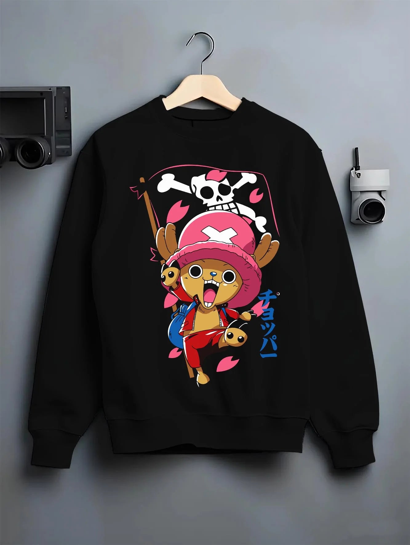 Black crewneck sweatshirt on hanger with Chopper Hoodie One Piece Doctor Pink Hat Skull Mark graphic streetwear graphic.