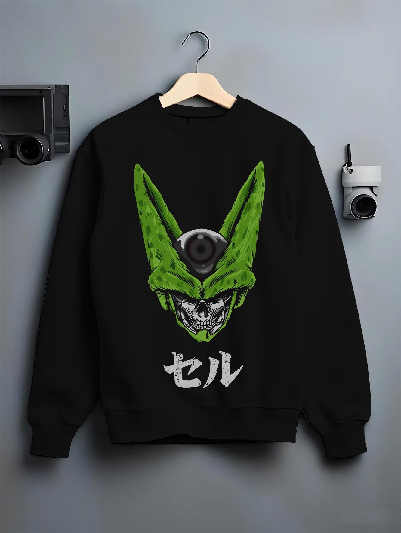 Black crewneck sweatshirt on a hanger against a grey wall, featuring Dragon Ball Cell skull fusion dark manga panel inspired artwork.