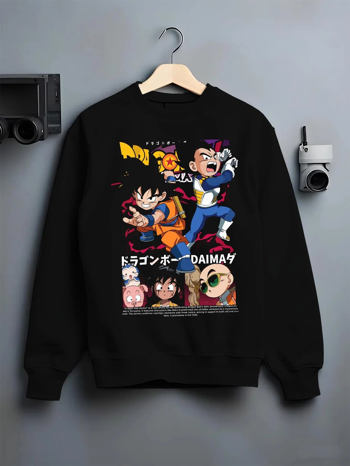 Black crewneck sweatshirt on hanger with Dragon Ball Hoodie Daima Series Chibi Retro Poster graphic Goku themed artwork.