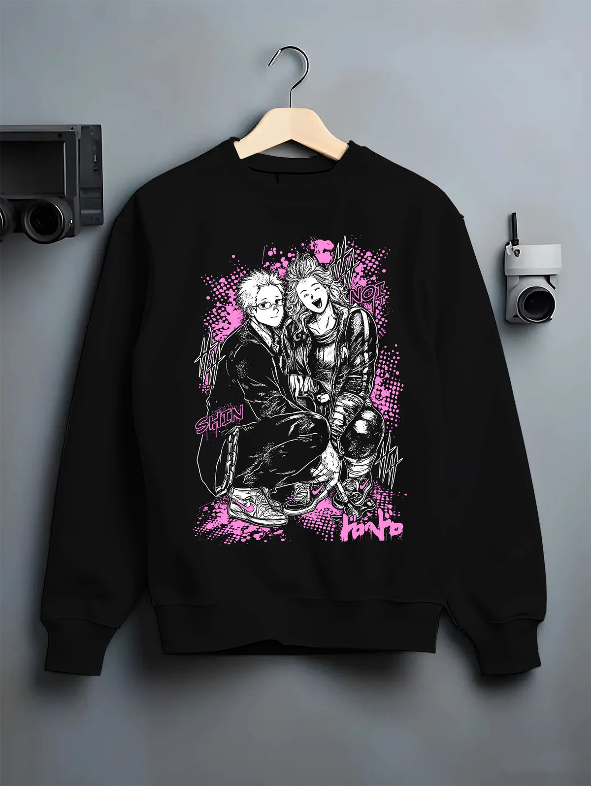 Black crewneck sweatshirt on hanger showing Dandadan: Okarun and Momo duo
