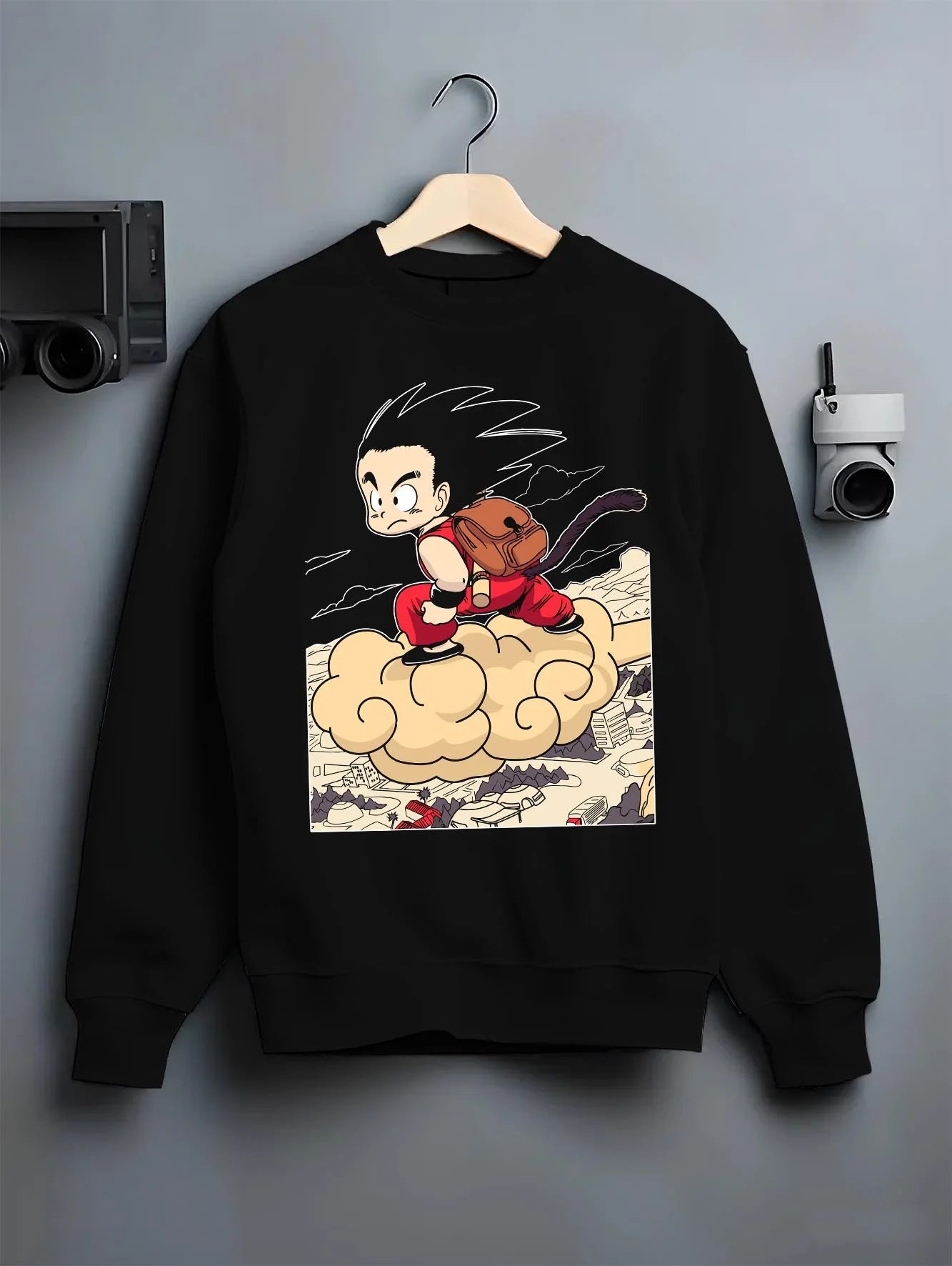 Black crewneck sweatshirt on hanger with Goku Hoodie Dragon Ball Kid Nimbus Cloud Adventure graphic premium wear.