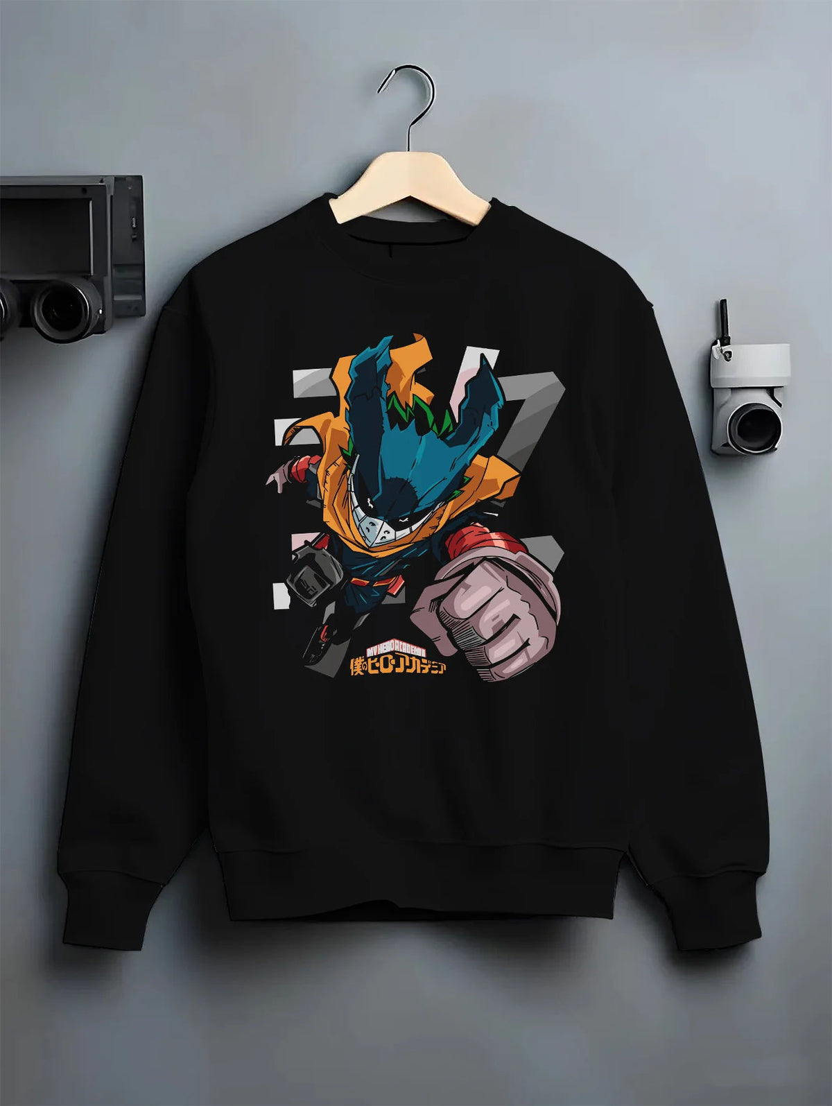 Black crewneck sweatshirt on hanger showing Deku from My Hero Academia: stylised chibi hero suit with extended fist
