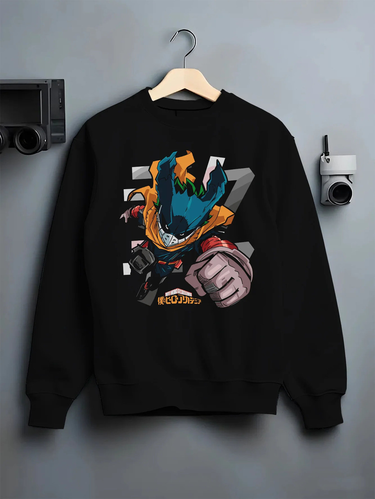 Black crewneck sweatshirt on hanger showing Deku from My Hero Academia: stylised chibi hero suit with extended fist