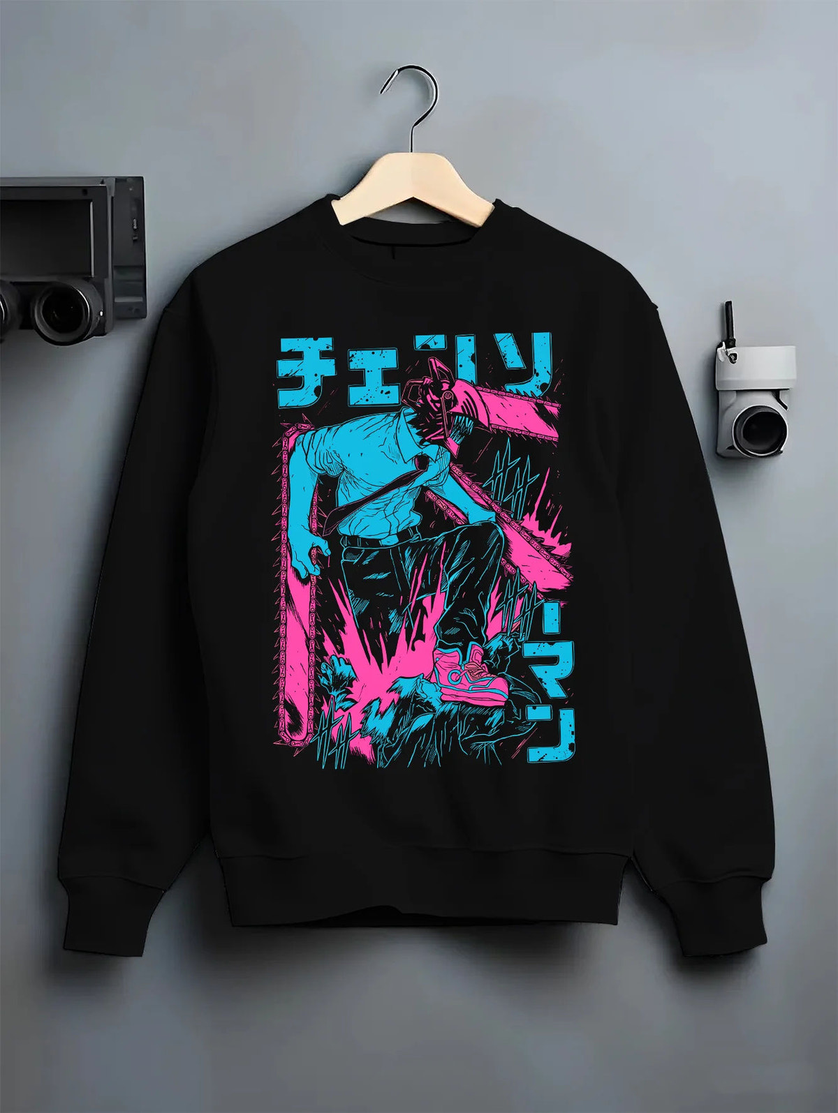 Black crewneck sweatshirt on hanger showing Chainsaw Devil / Denji from Chainsaw Man: cyan and magenta standing silhouette