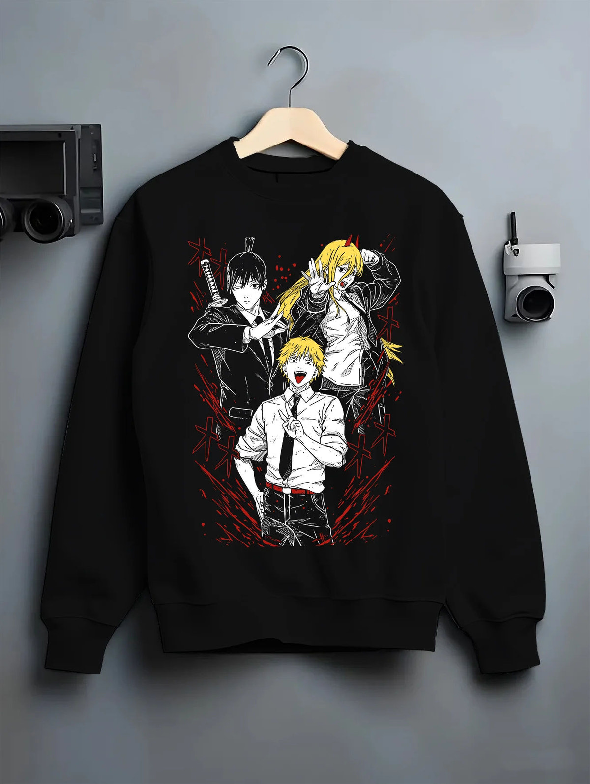 Black crewneck sweatshirt on hanger showing Denji with Power and Aki from Chainsaw Man: manga collage