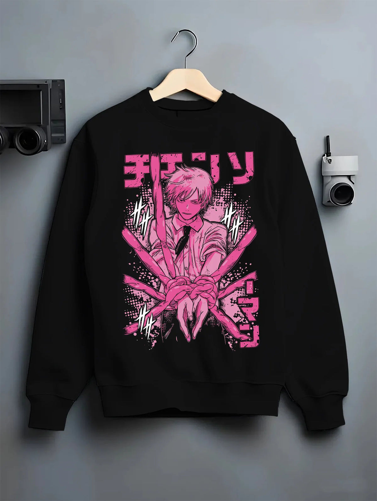 Black crewneck sweatshirt on hanger showing Denji / Chainsaw Man character: pink manga-style portrait