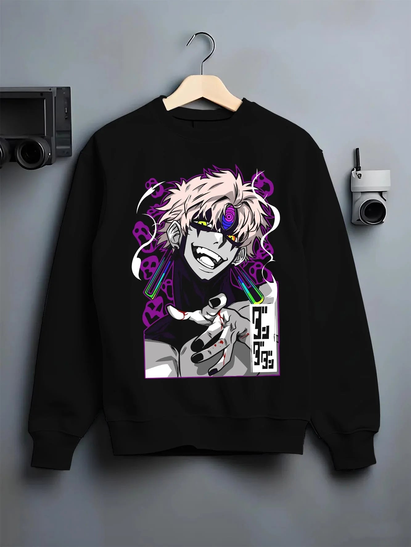Black crewneck sweatshirt on hanger with Dandadan Hoodie Spirit Paranormal Duo Retro Battle graphic bold anime graphic.