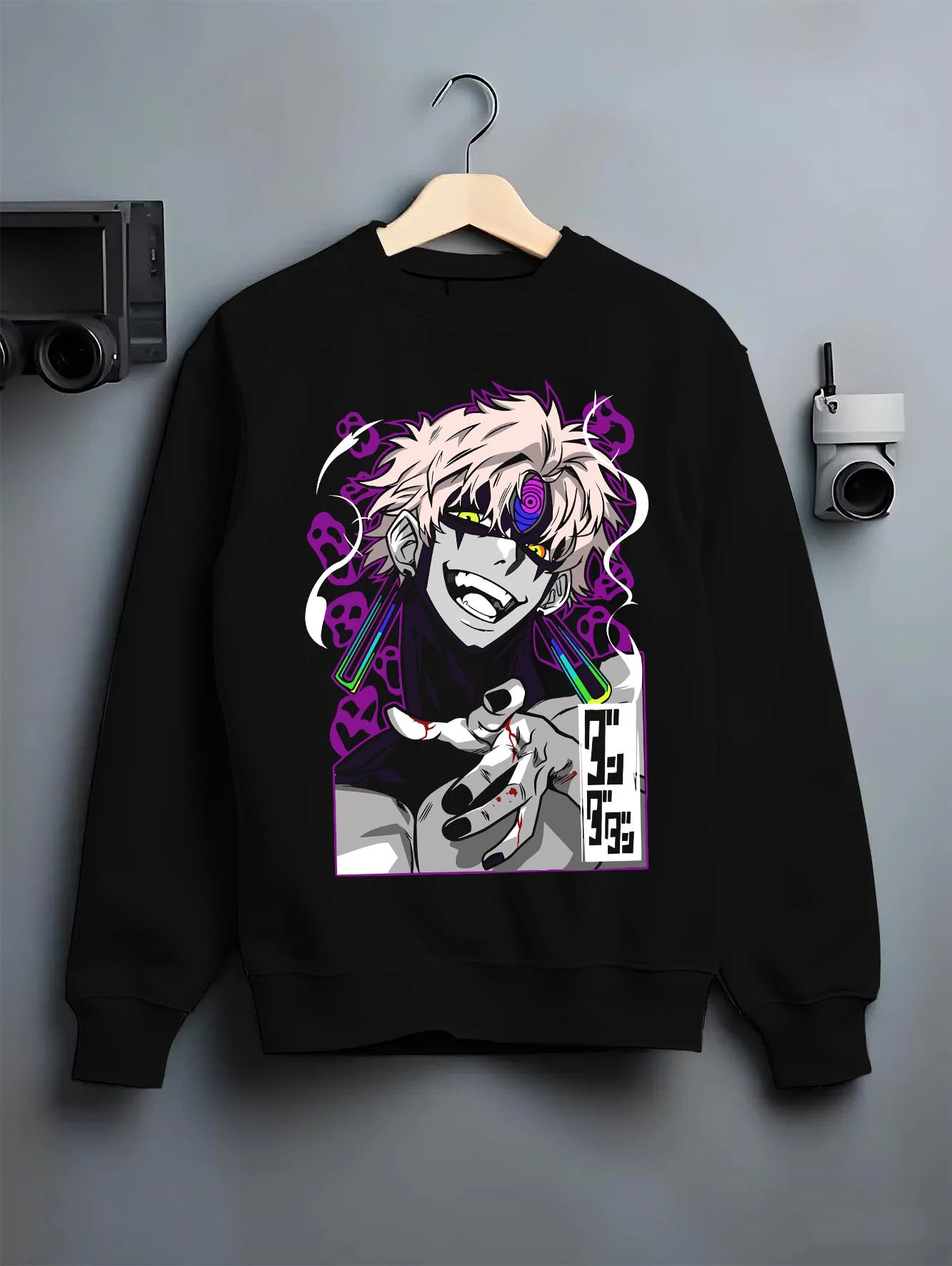 Black crewneck sweatshirt on hanger with Dandadan Hoodie Spirit Paranormal Duo Retro Battle graphic bold anime graphic.