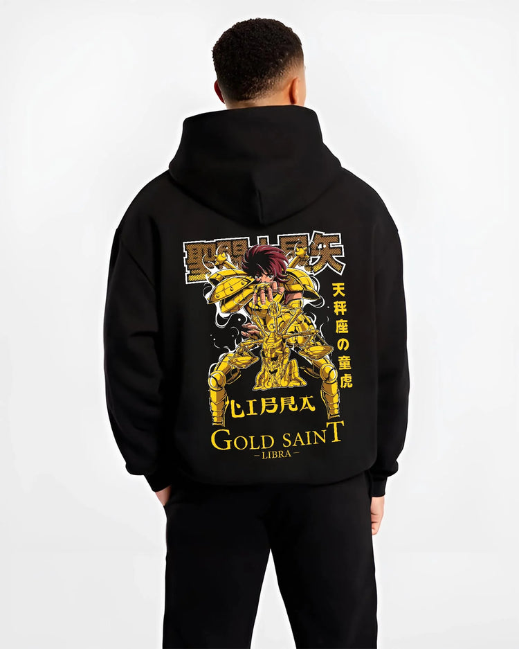 Black hoodie worn by male model, back view with Libra Hoodie Saint Seiya Gold Saint Armour Retro graphic bold anime graphic.