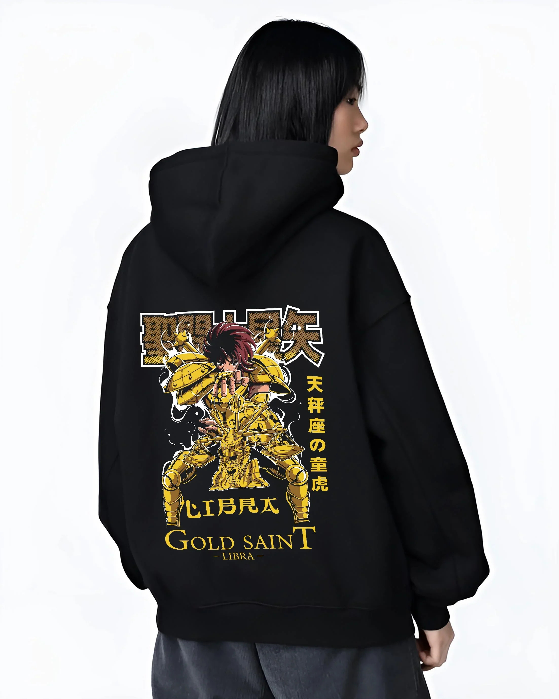 Black hoodie worn by female model, back view with Libra Hoodie Saint Seiya Gold Saint Armour Retro graphic bold anime graphic.