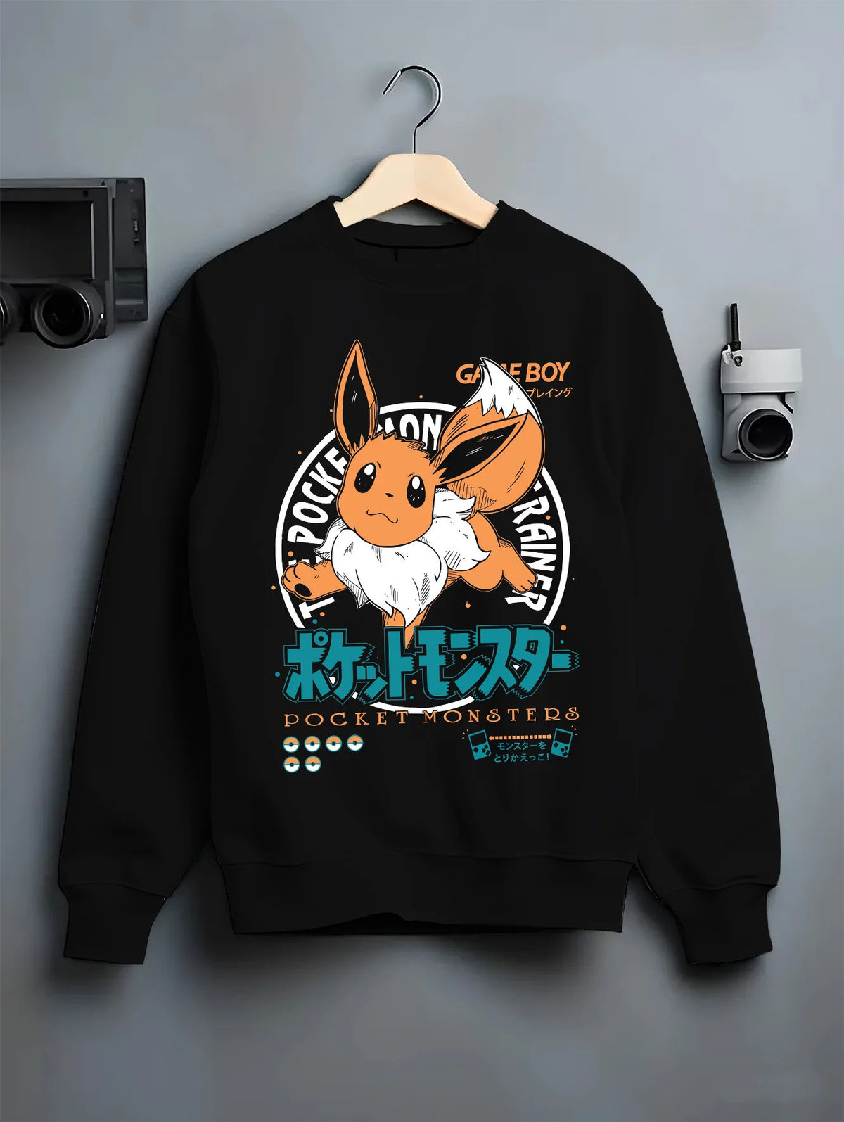 Black crewneck sweatshirt on hanger showing Eevee from Pokémon: Pokémon cartoon with orange circular motif