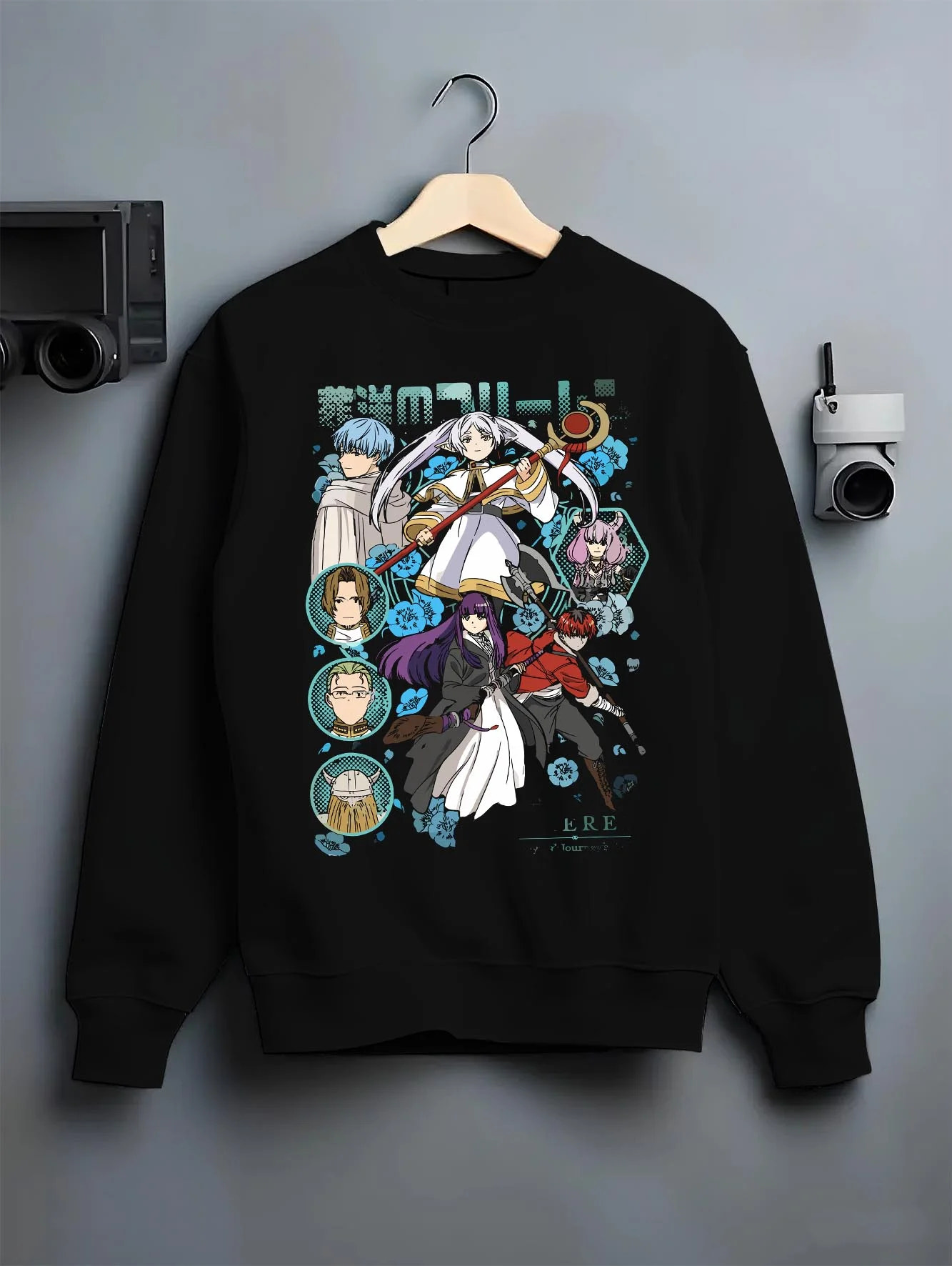 Black crewneck sweatshirt on hanger with Frieren Hoodie Beyond Journey’s End Adventure Cast graphic premium wear.