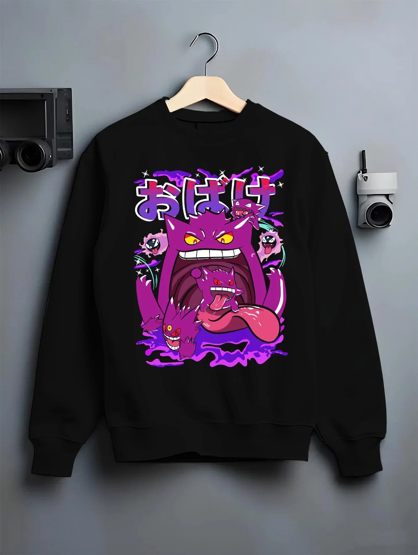 Black crewneck sweatshirt on hanger with Pokémon Hoodie Gengar Spooky Ghost Jumper graphic bold anime graphic.