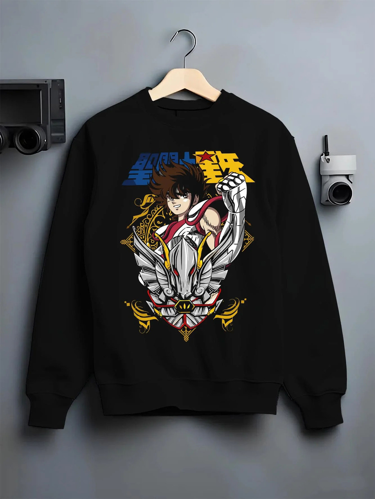 Black crewneck sweatshirt on hanger featuring Pegasus Seiya Saint Seiya gold wings artwork.