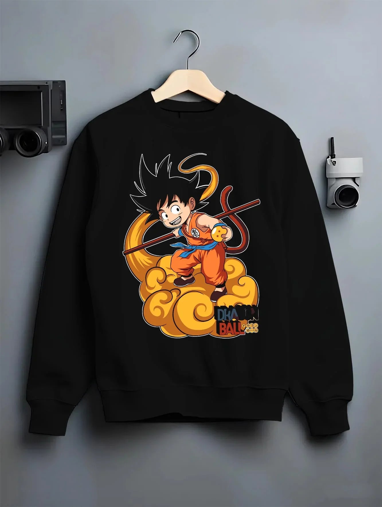 Black crewneck sweatshirt on hanger with Dragon Ball Z Hoodie Kid Goku Nimbus Jumper graphic bold anime graphic.