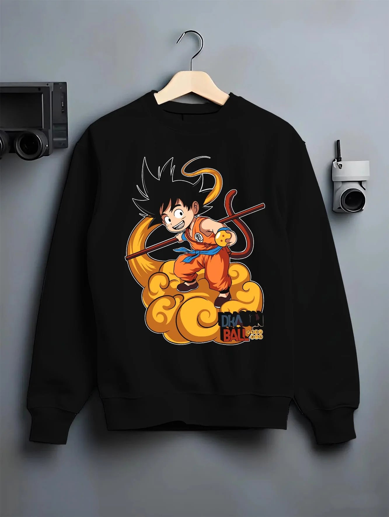 Black crewneck sweatshirt on hanger with Dragon Ball Z Hoodie Kid Goku Nimbus Jumper graphic bold anime graphic.
