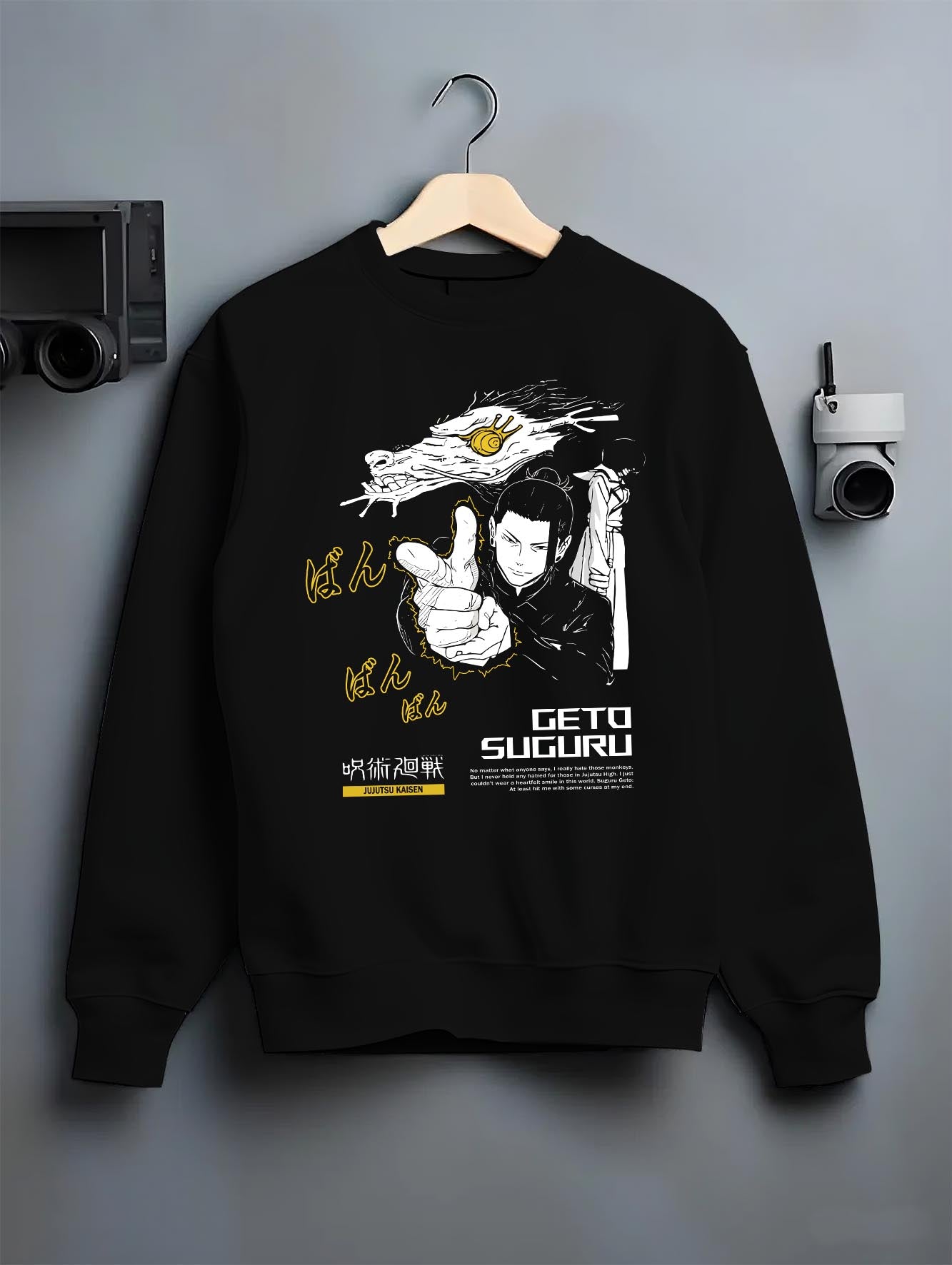 Black crewneck sweatshirt on a hanger against a grey wall, featuring Geto Suguru anime poster inspired artwork in dark manga panel style with retro streetwear vibe.